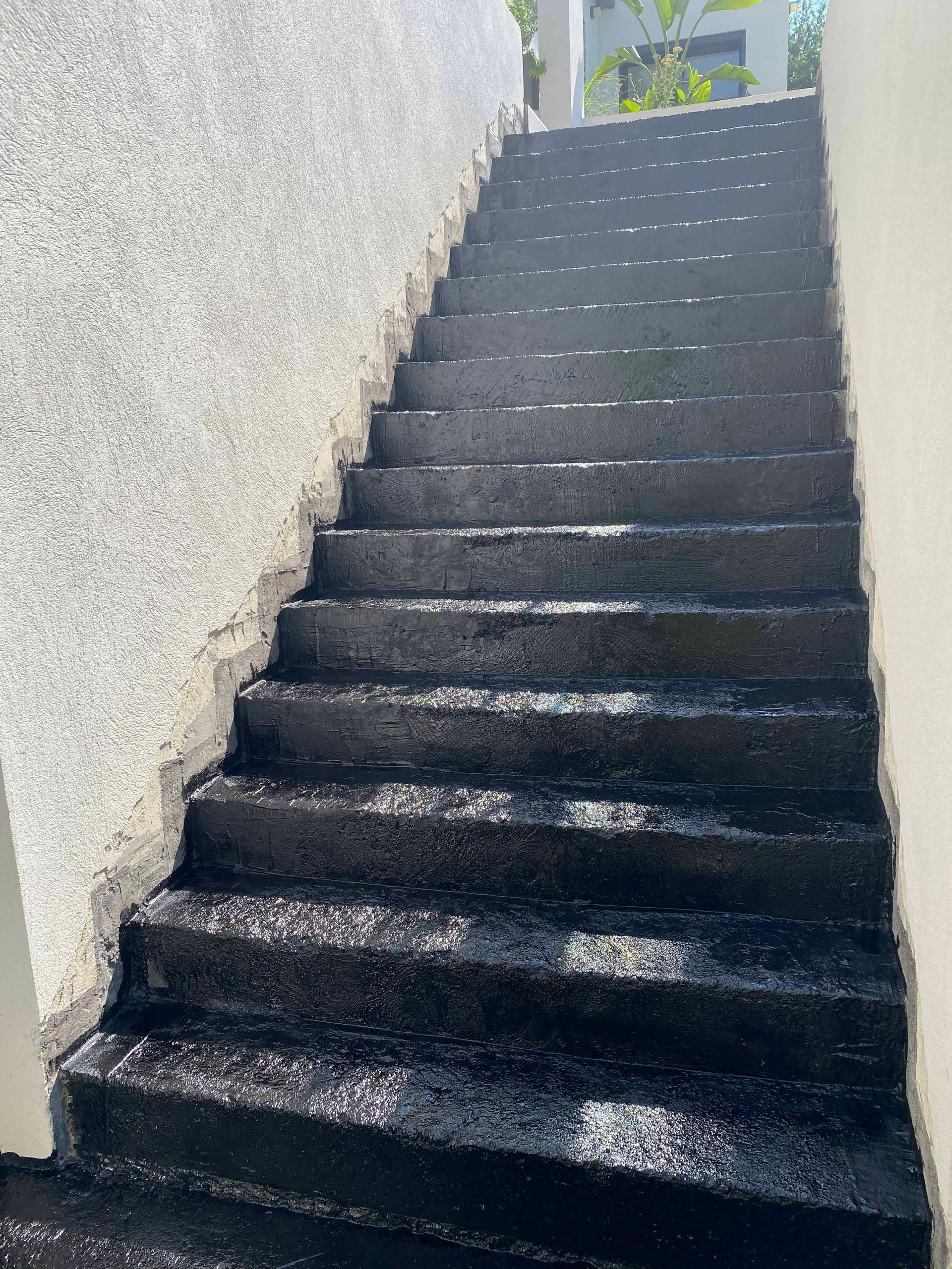 Un ensemble d'escaliers noirs menant à un bâtiment.