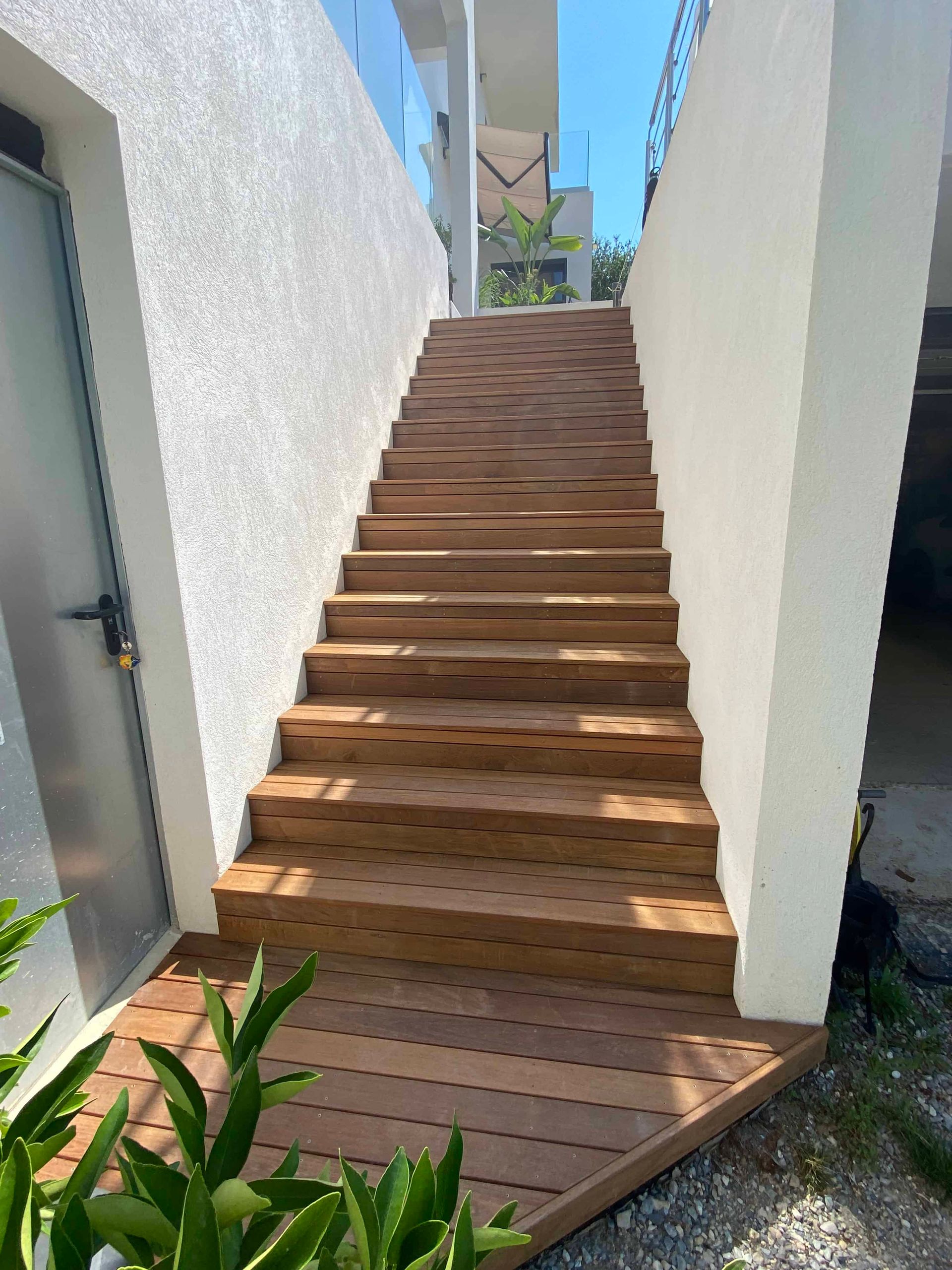 Un ensemble d'escaliers en bois menant à un bâtiment blanc.