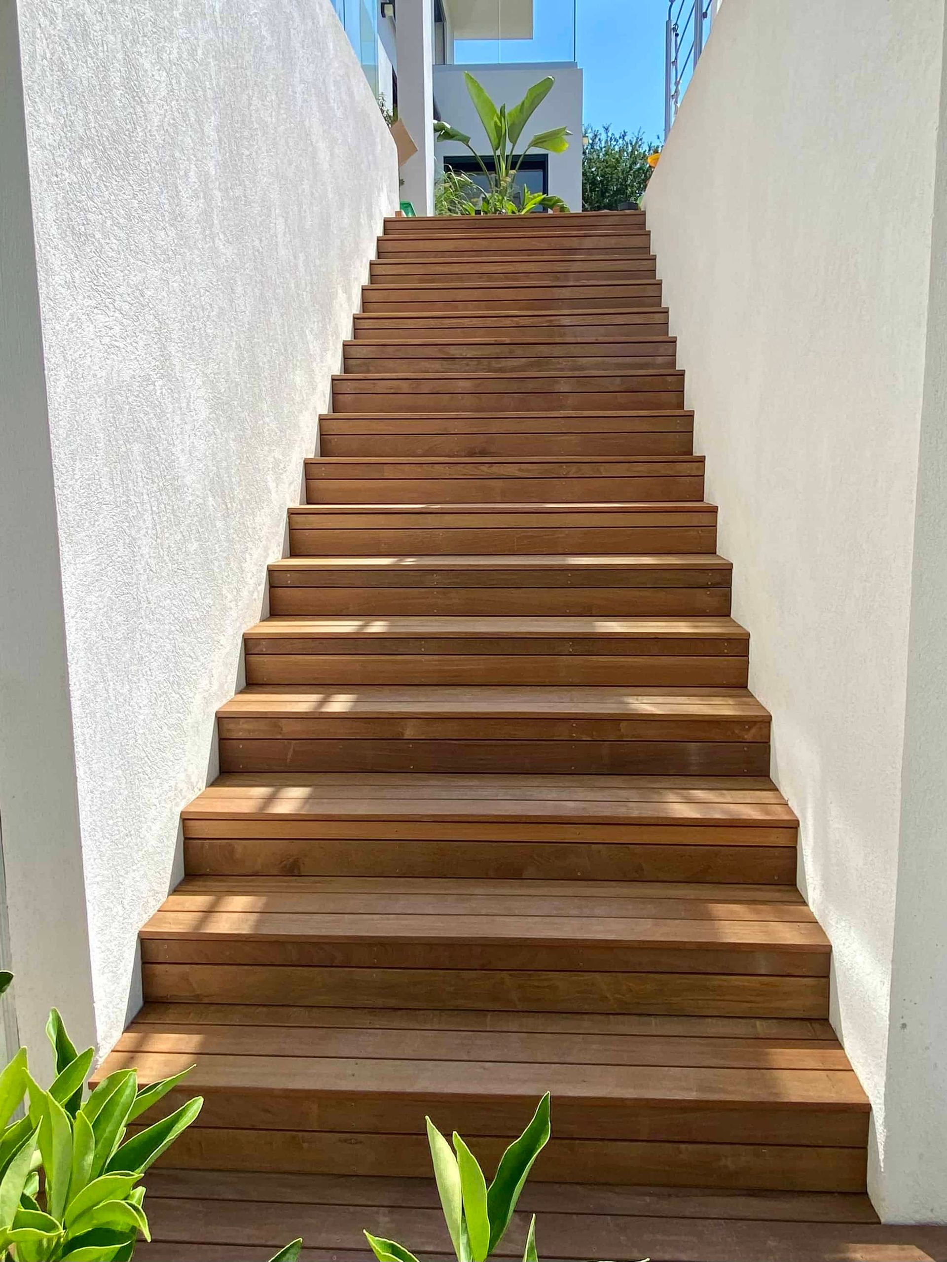 Un ensemble d'escaliers en bois menant à un mur blanc.
