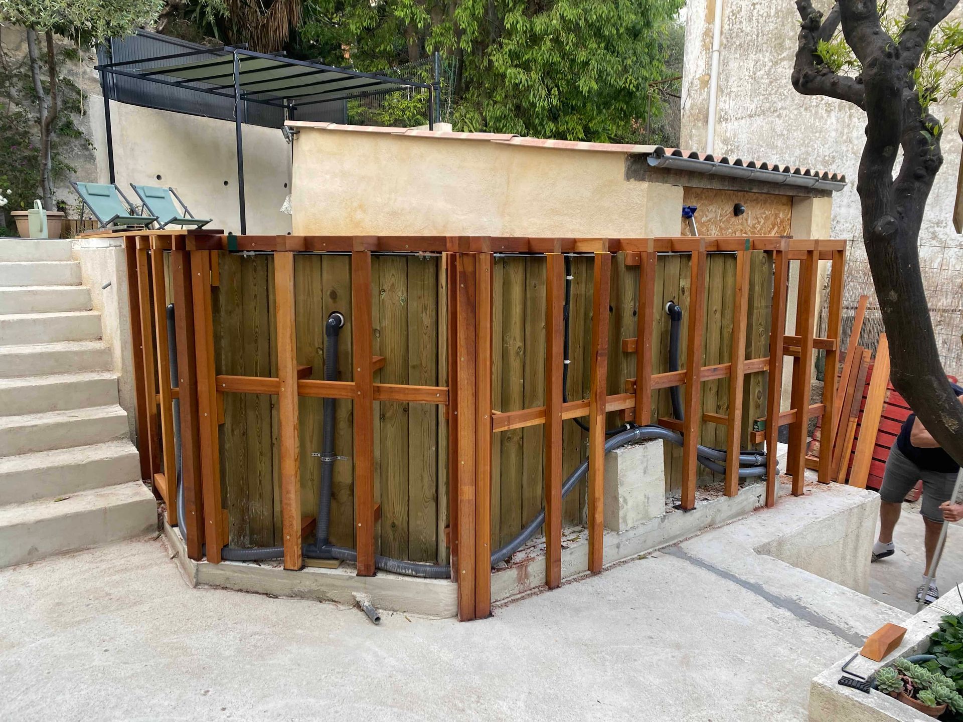 Une clôture en bois est en train d'être construite autour d'une piscine.