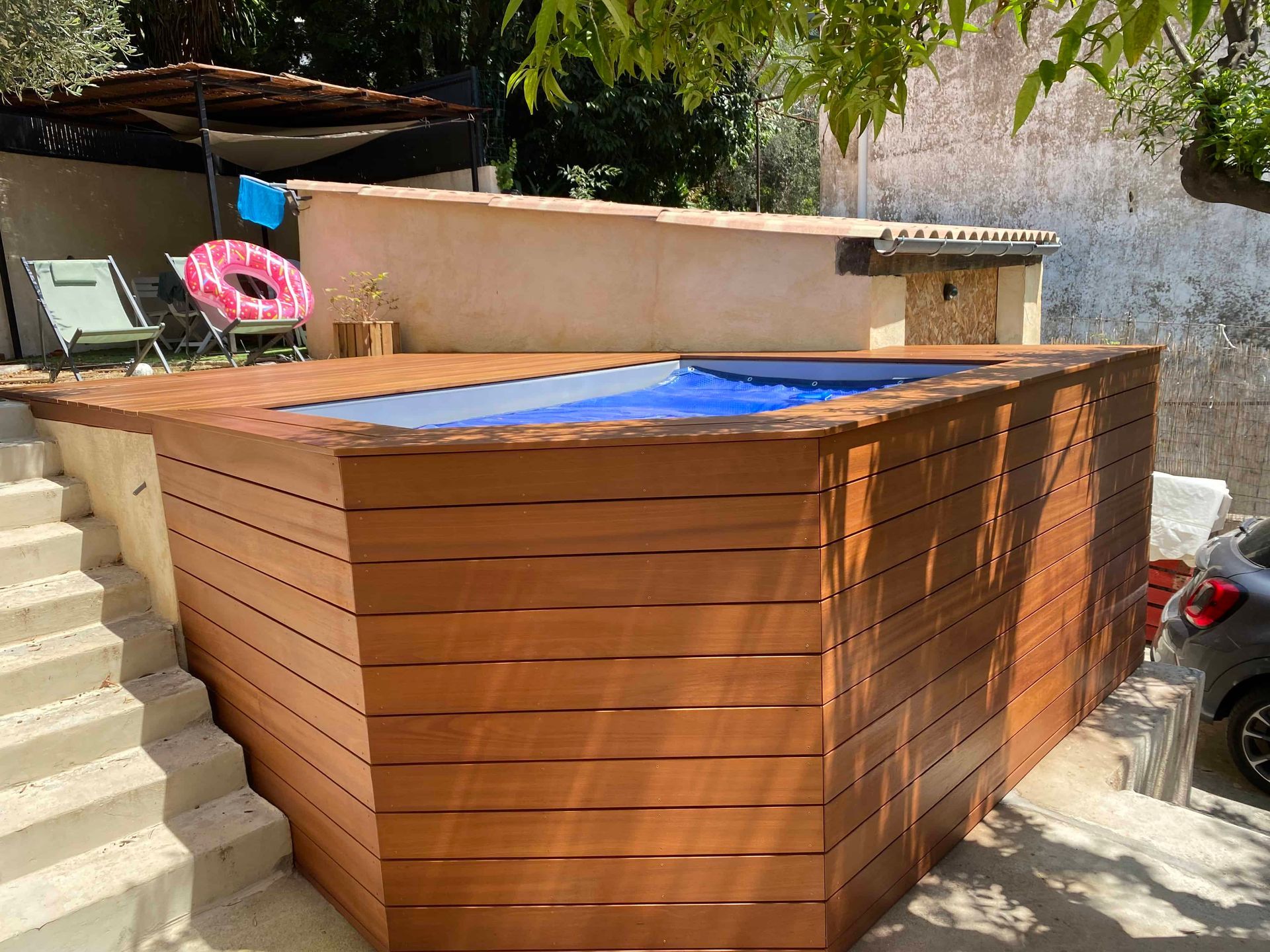 Une clôture en bois entoure une petite piscine.