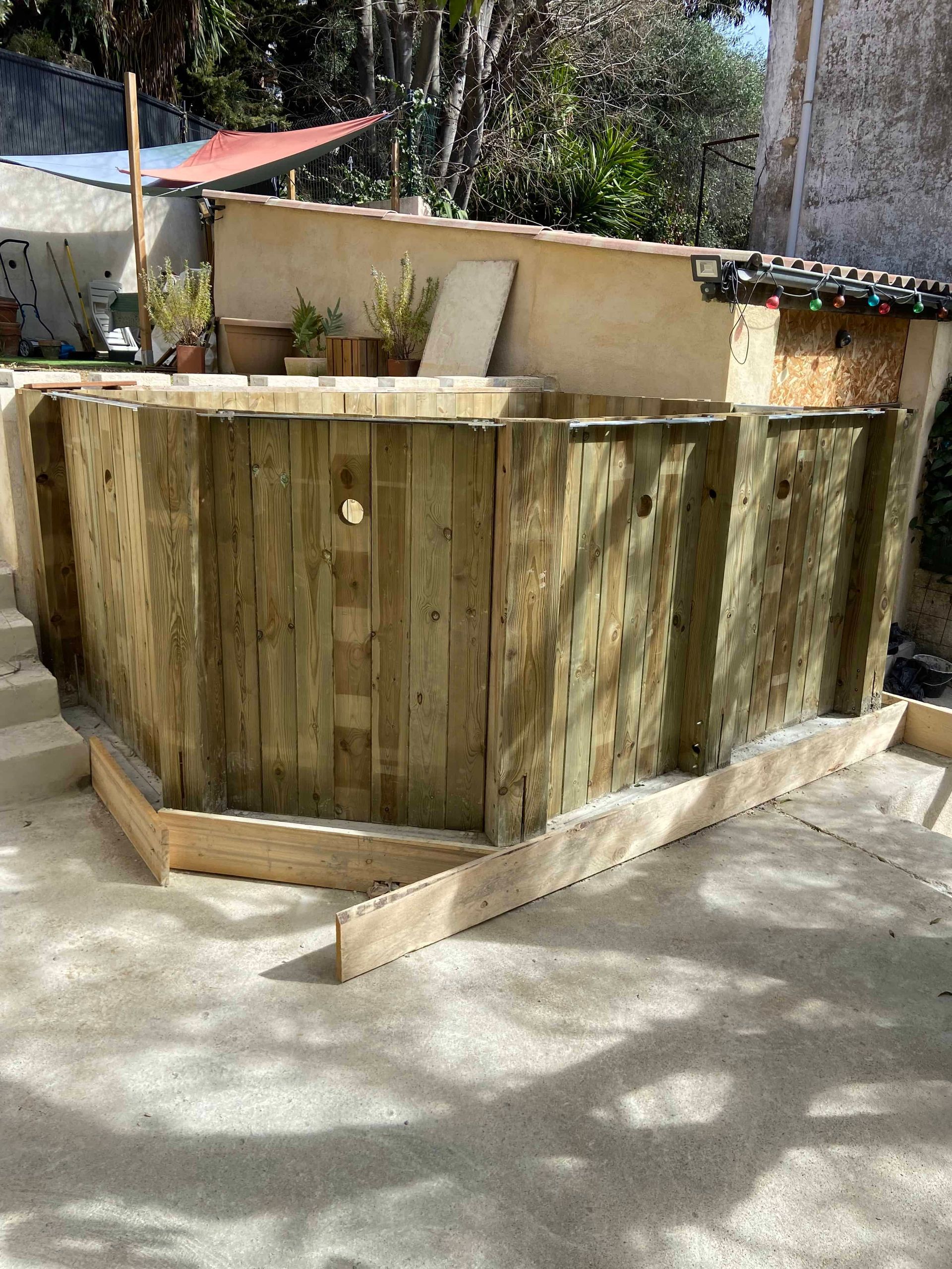 Une clôture en bois est en train d'être construite dans une cour arrière.