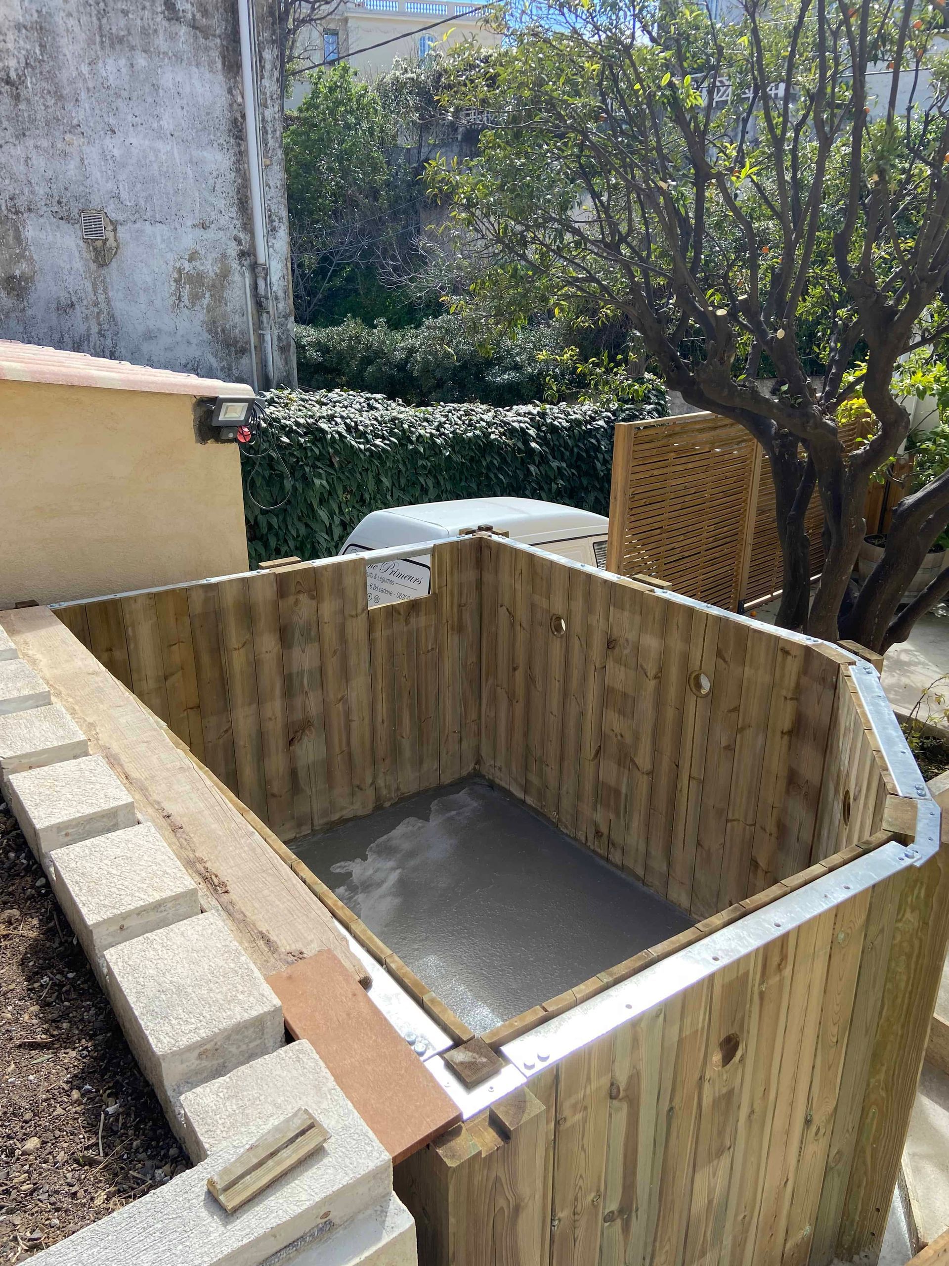 Un hangar en bois est en cours de construction dans une cour arrière.