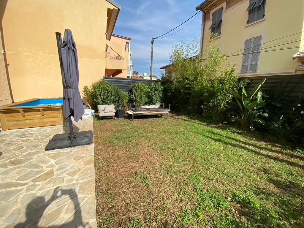 Une grande pelouse avec une piscine dans l'arrière-cour d'une maison.