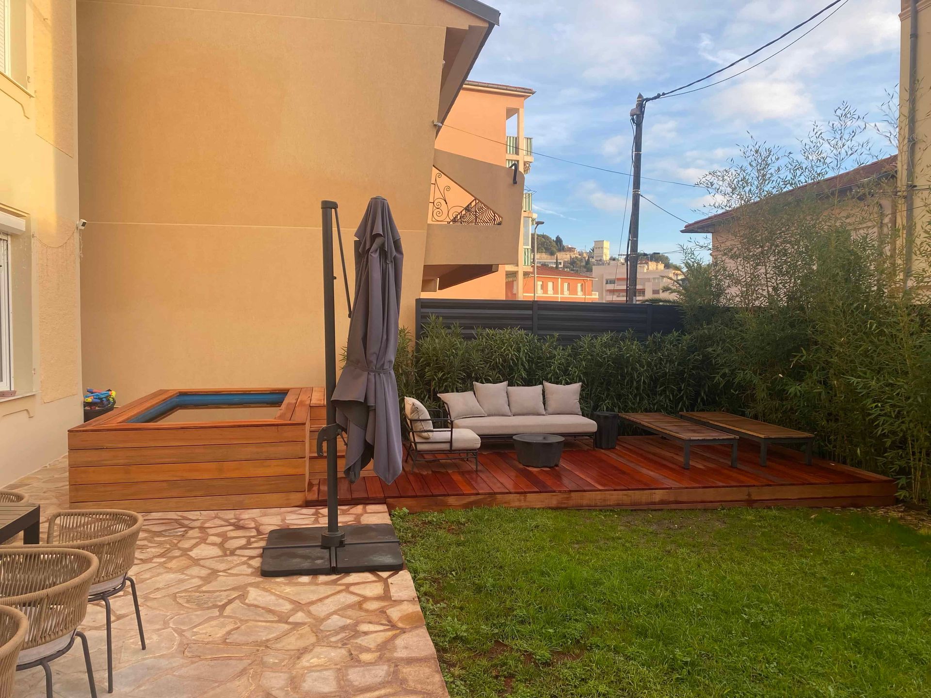 Il y a une terrasse en bois avec un canapé et des chaises dans l'arrière-cour.