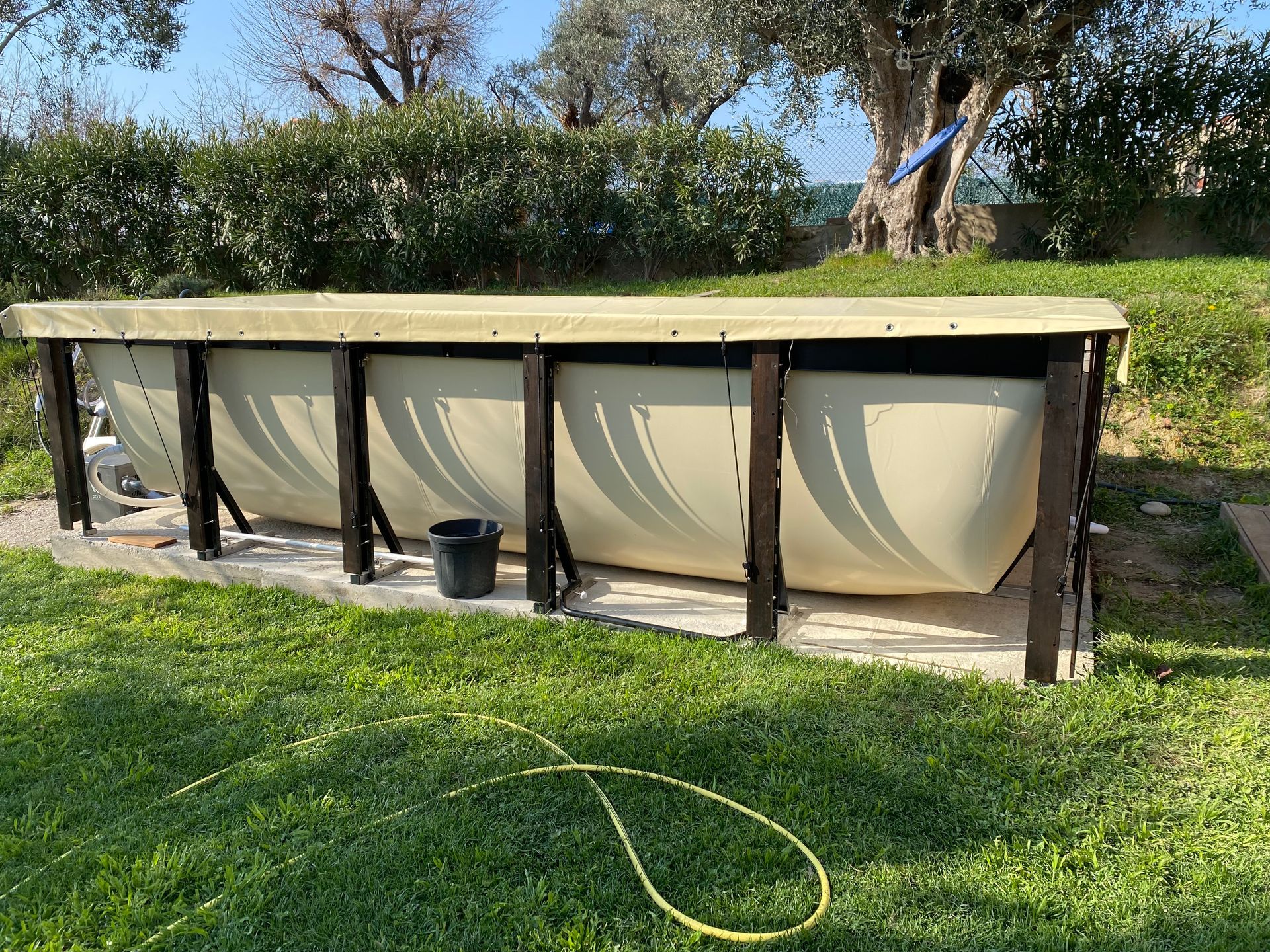 Une grande piscine se trouve au milieu d'un champ verdoyant.
