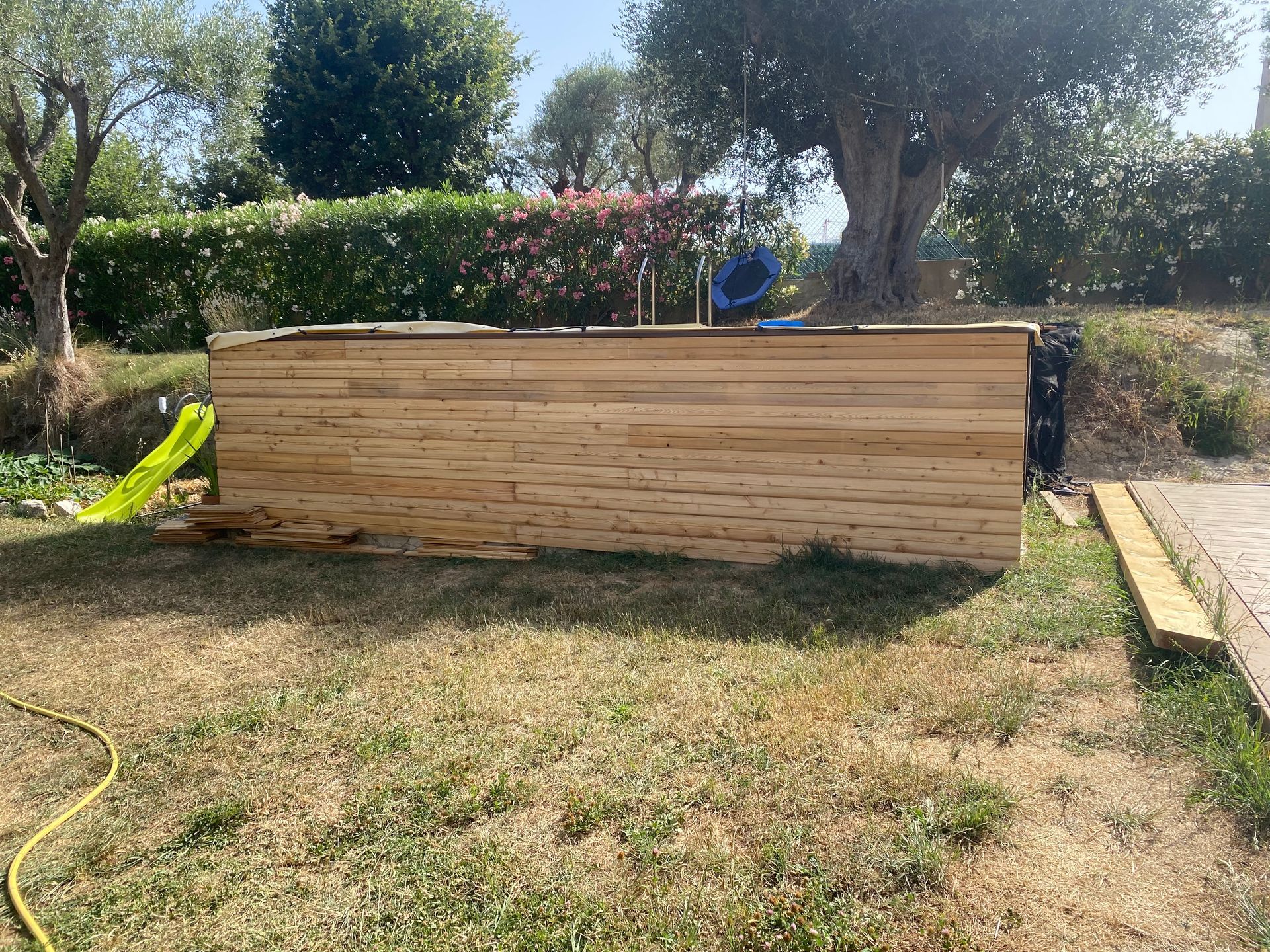 Une piscine en bois est en cours de construction dans une cour arrière.