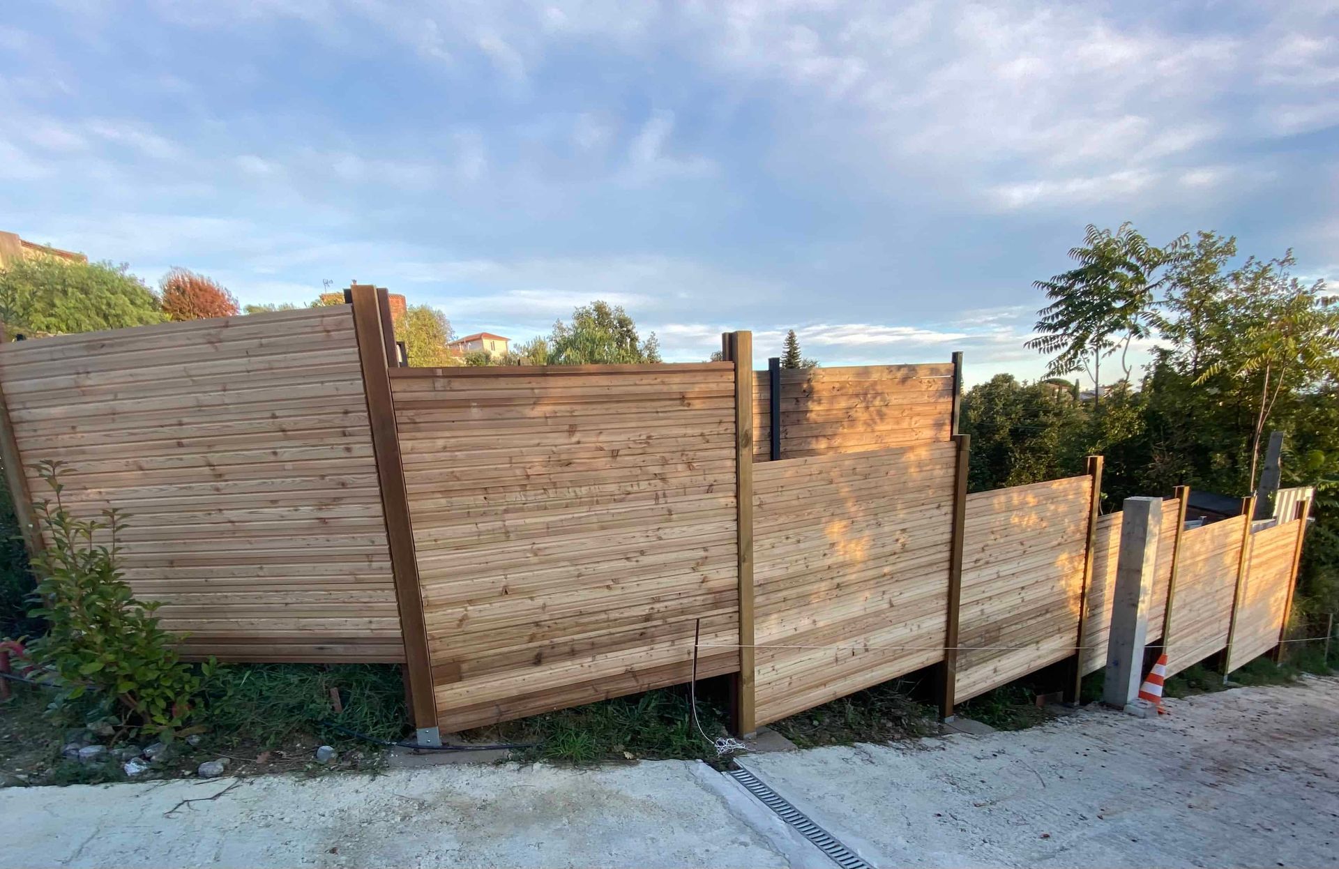 Une clôture en bois est posée au sommet d'une colline de terre.