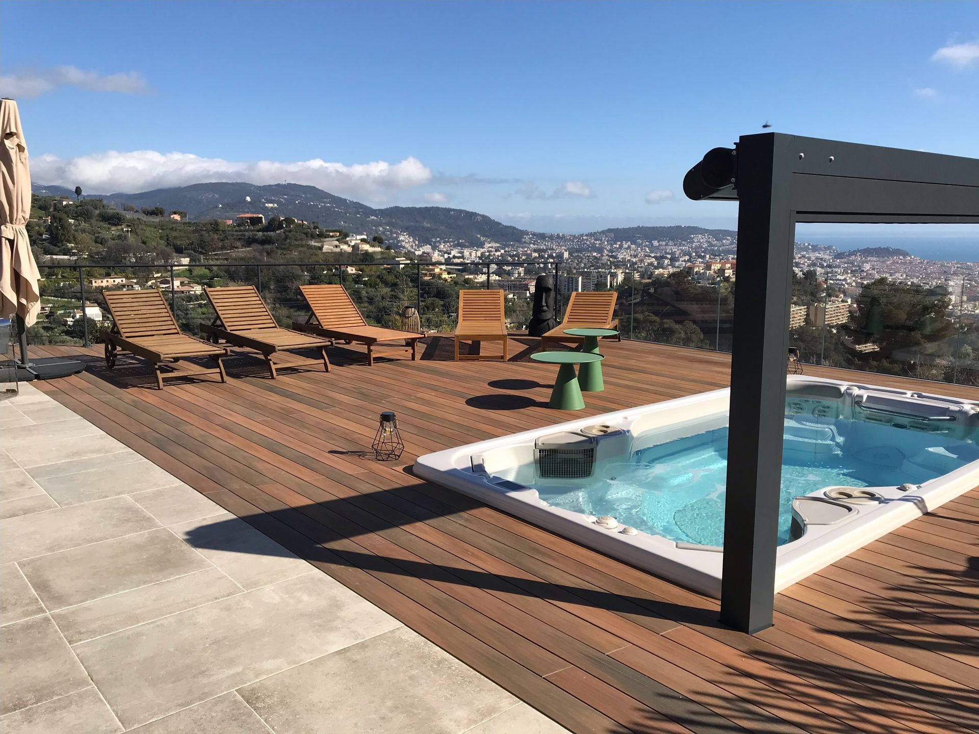 Une piscine sur une terrasse avec chaises et parasols