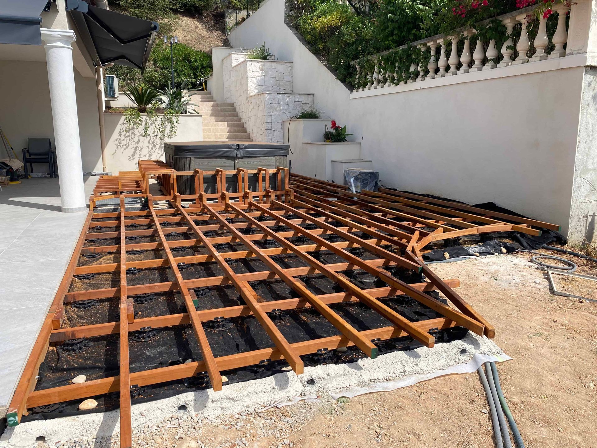 Une terrasse en bois est en cours de construction dans l'arrière-cour d'une maison.