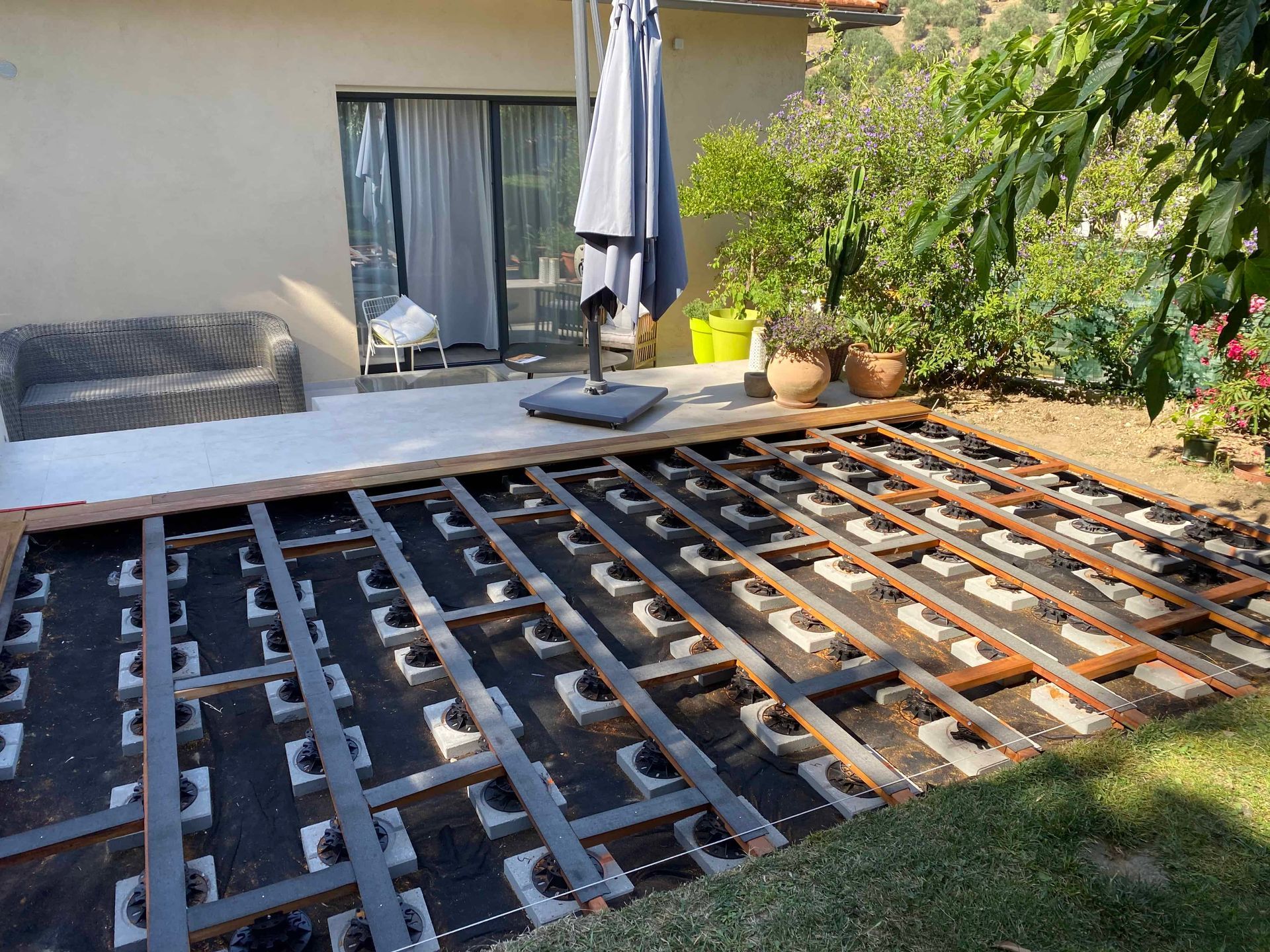Une terrasse en bois est en cours de construction dans une cour arrière.
