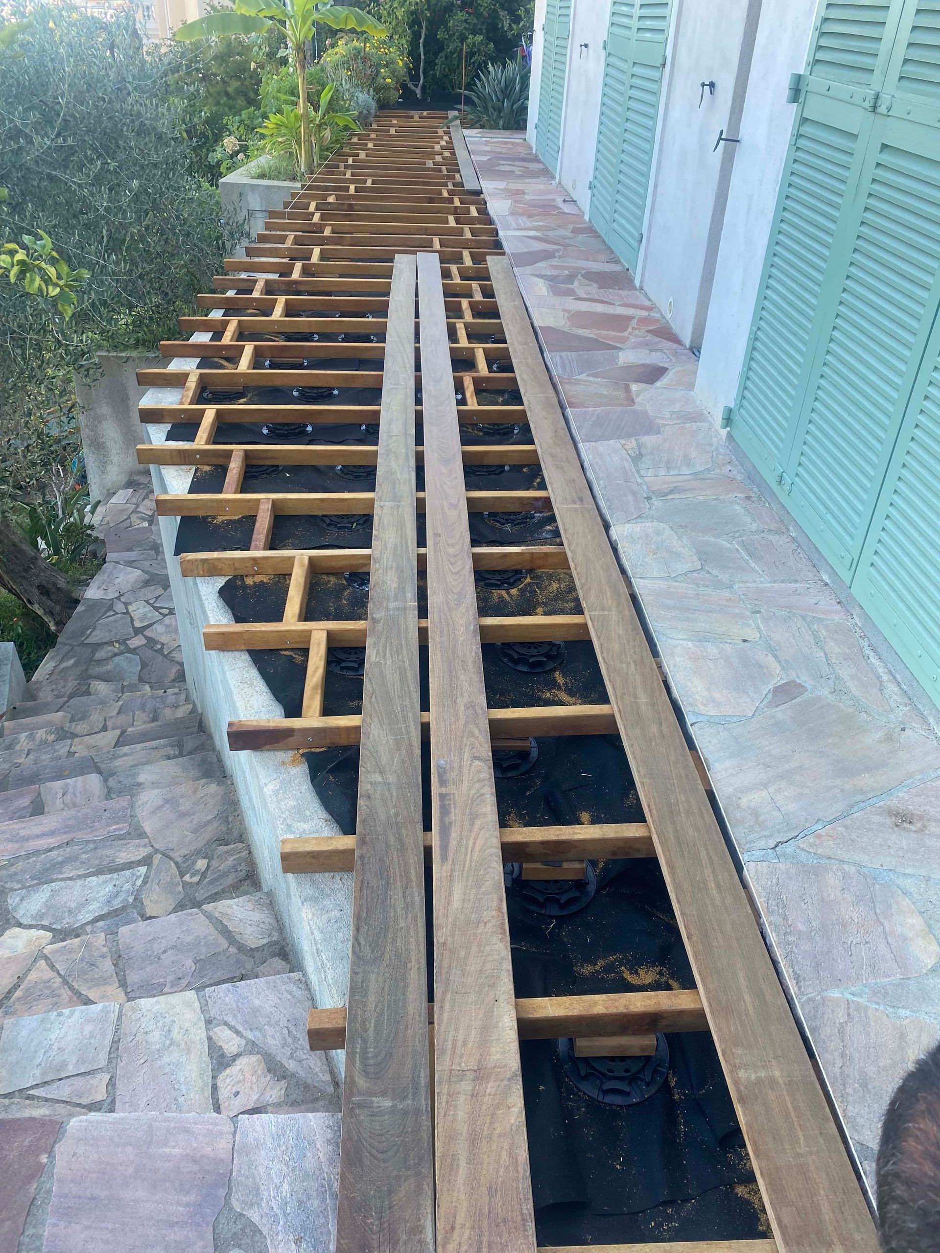 Une terrasse en bois est en cours de construction sur le côté d'un bâtiment.