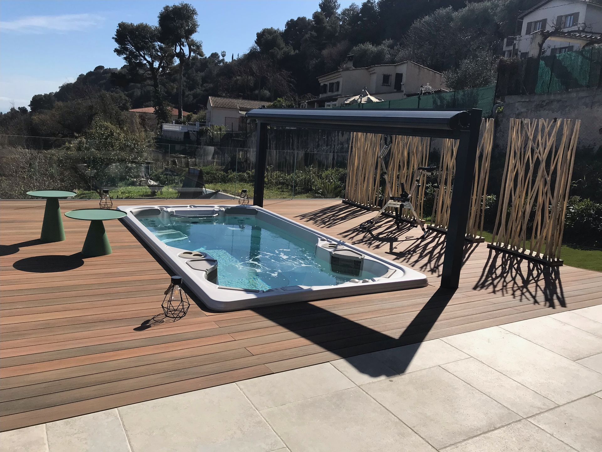 Une grande piscine est entourée d'une terrasse en bois composite
