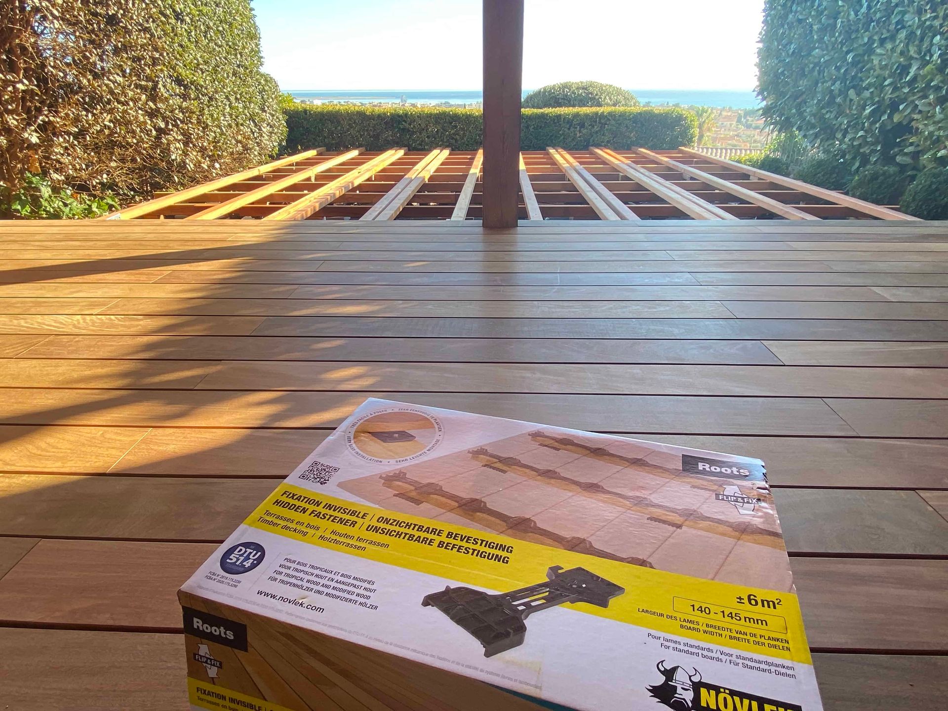 Une boîte avec un bulldozer dessus est posée sur une terrasse en bois.