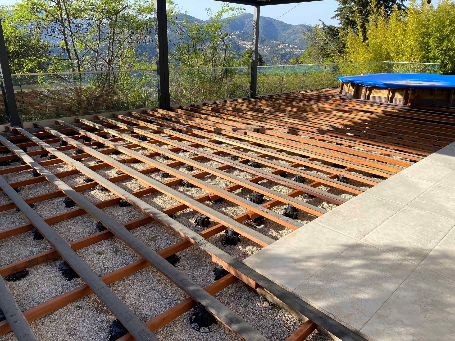 Une terrasse en bois est en cours de construction à côté d'une piscine.