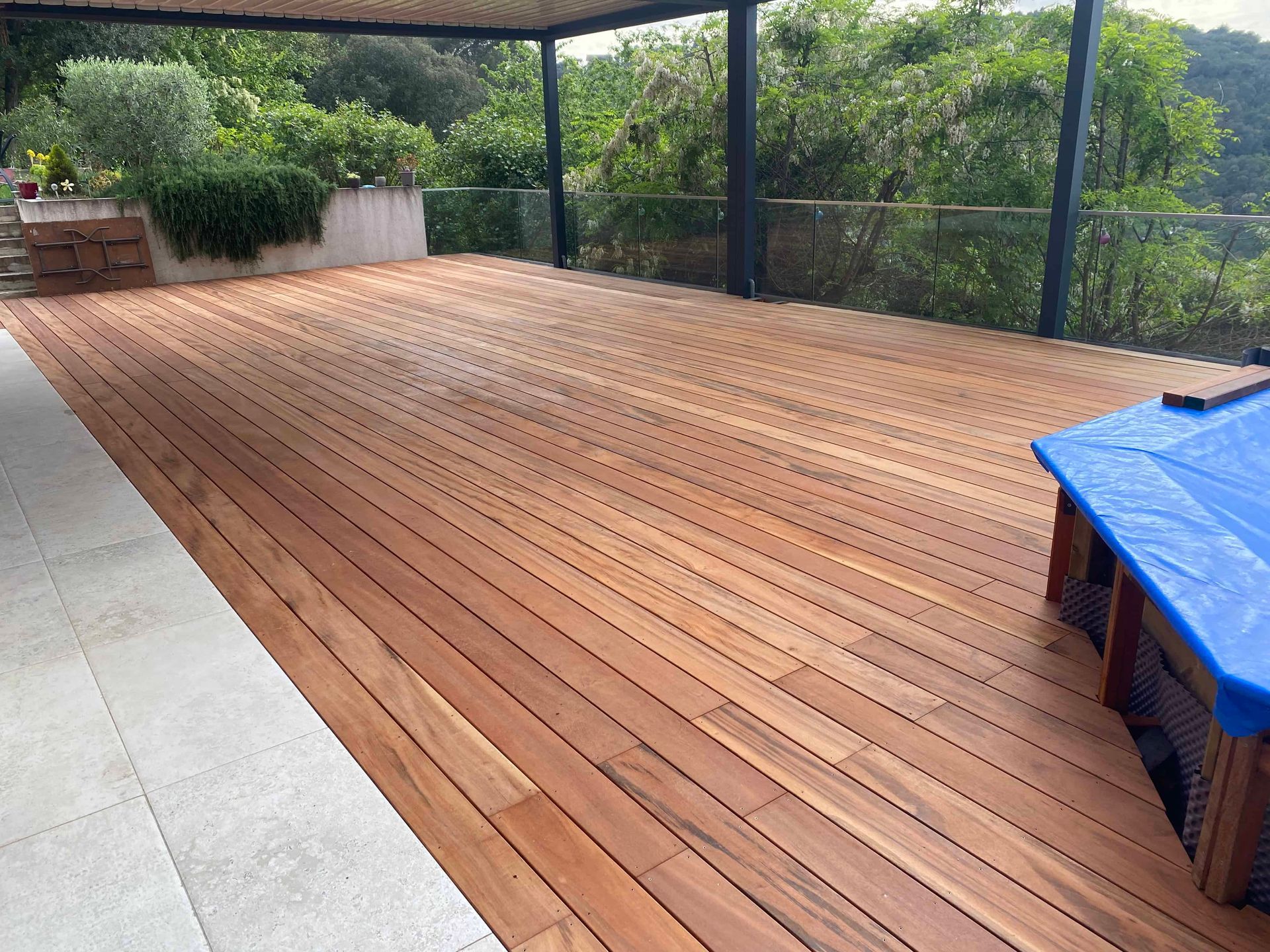 Une grande terrasse en bois avec une couverture bleue dessus