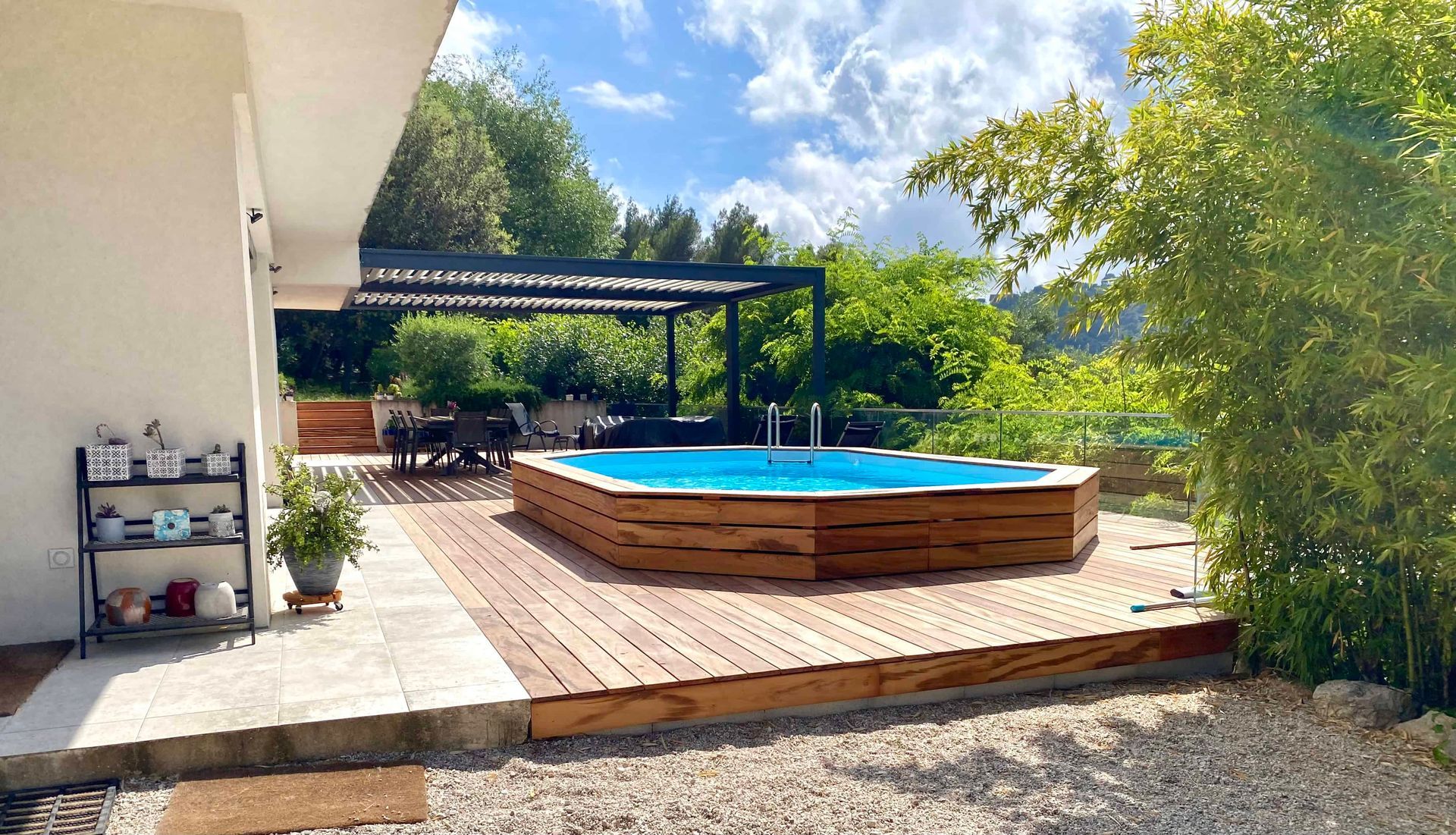 Une grande piscine est située au sommet d'une terrasse en bois.
