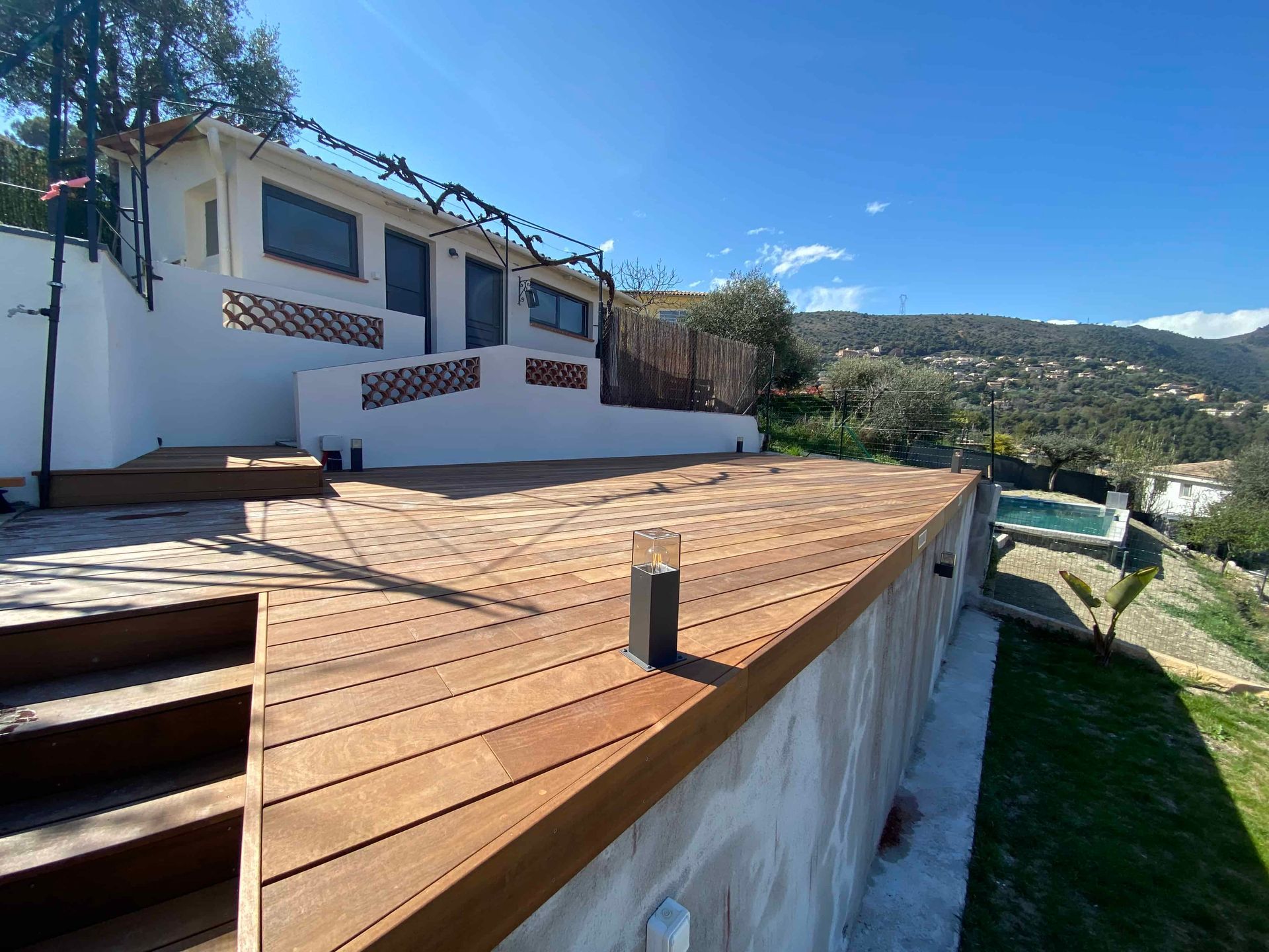 Une maison avec une terrasse en bois et des escaliers qui y mènent