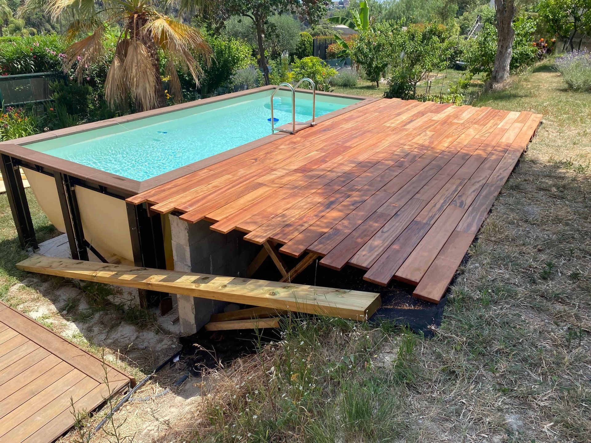 Une terrasse en bois Miuracatiara est située à côté d'une piscine.