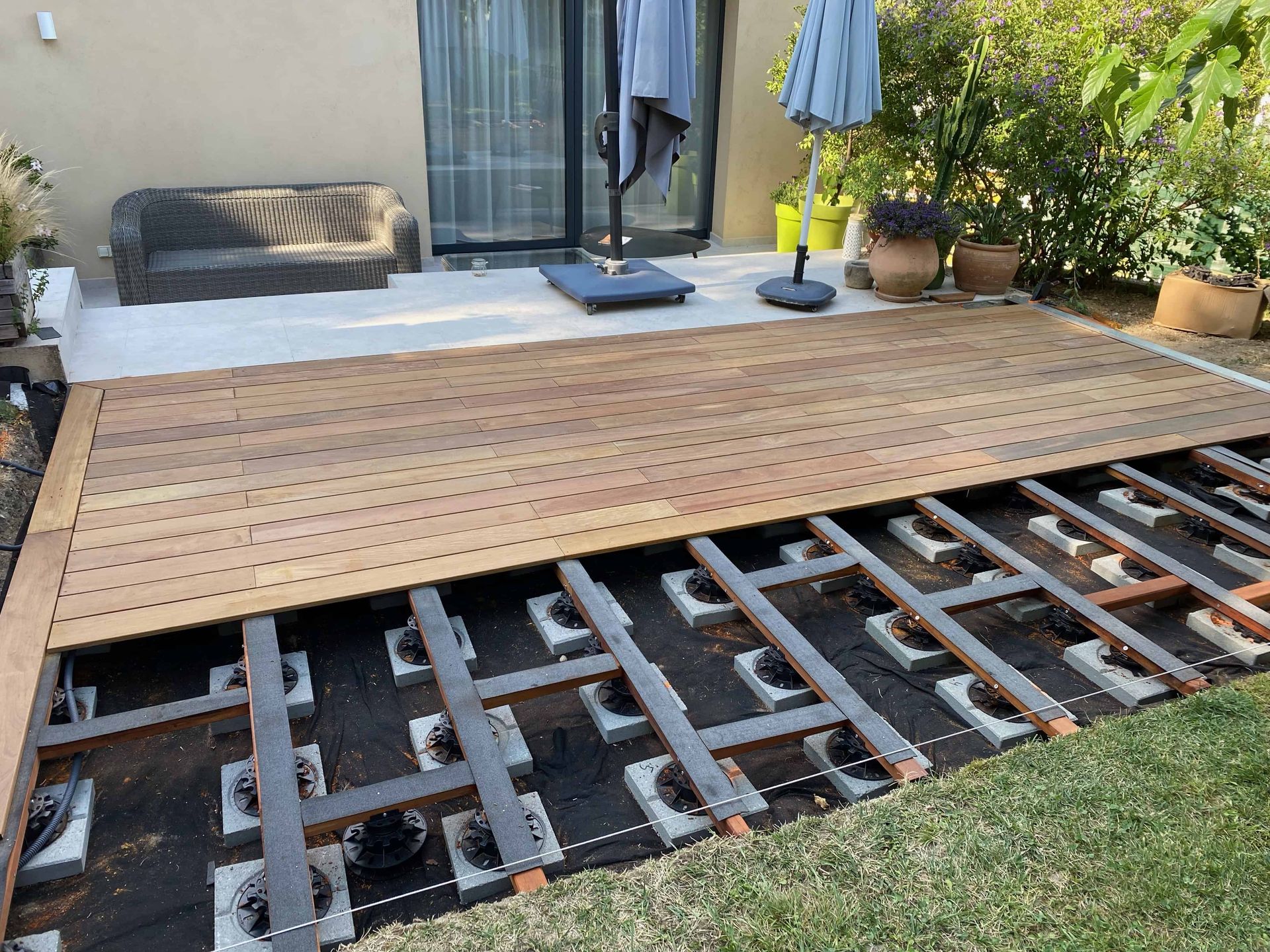 Une terrasse en bois est en cours de construction dans une cour arrière.