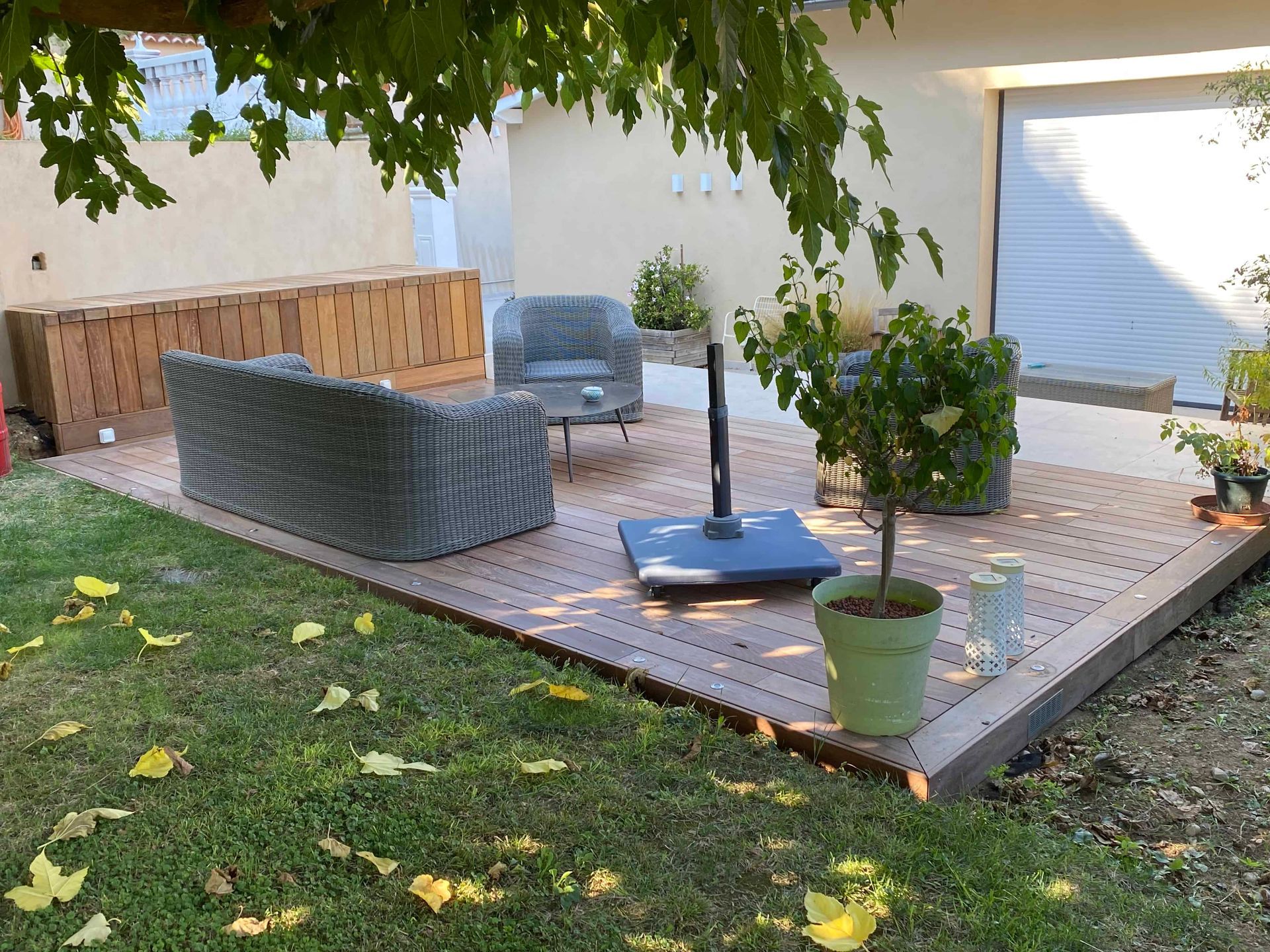 Une terrasse en bois avec un canapé et des chaises dessus