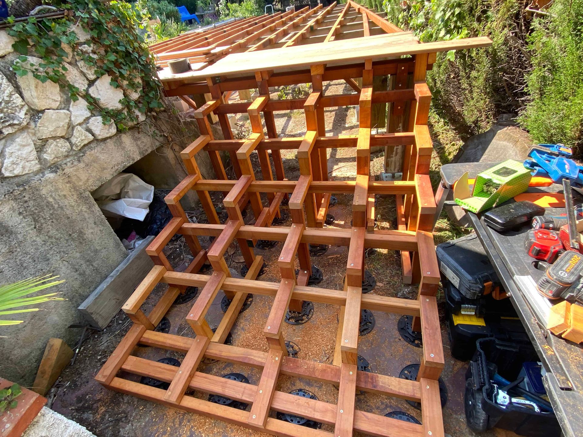 Un casier à vin en bois est en cours de construction dans un jardin