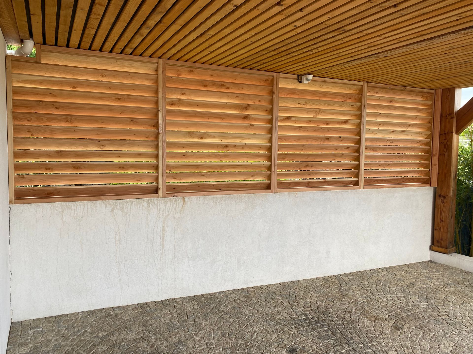 Brise-vue façon persienne en bois de Douglas, combinant élégance naturelle et protection visuelle pour vos extérieurs.