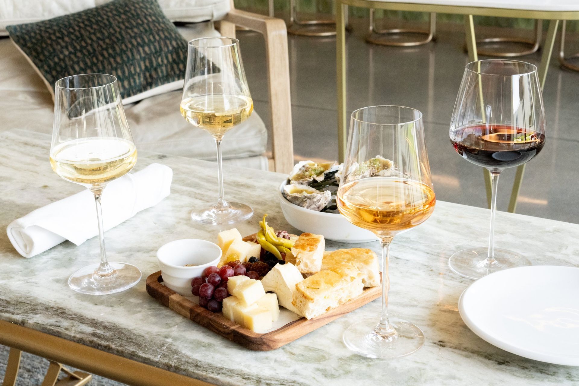 A table topped with plates of food and wine glasses.