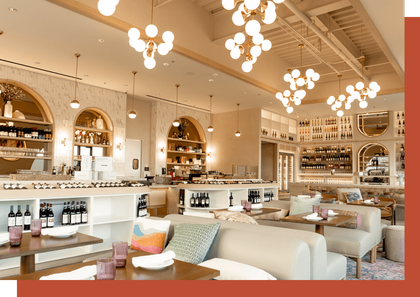 Elegant, well-lit restaurant interior with arched shelving, cozy seating, and modern globe pendant lights.