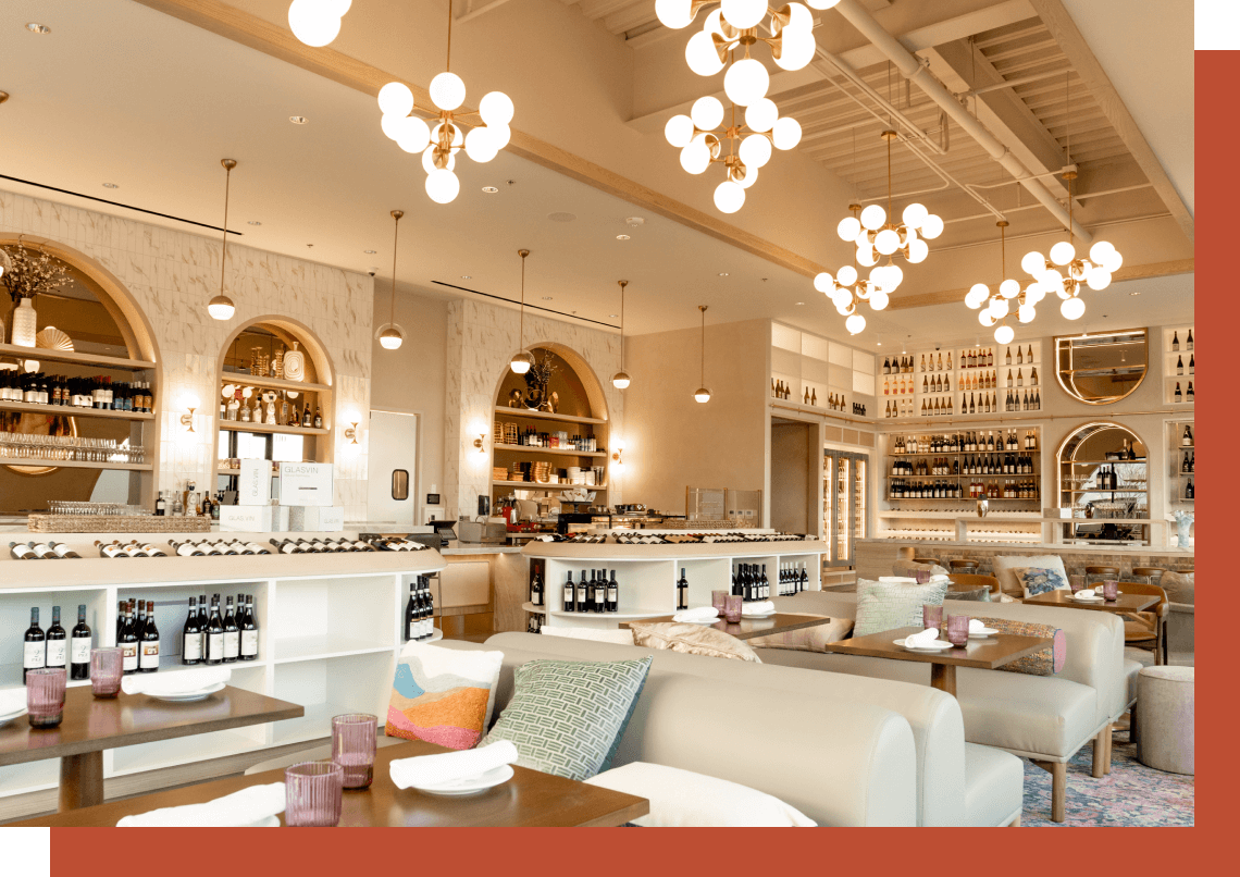 Elegant, well-lit restaurant interior with arched shelving, cozy seating, and modern globe pendant lights.