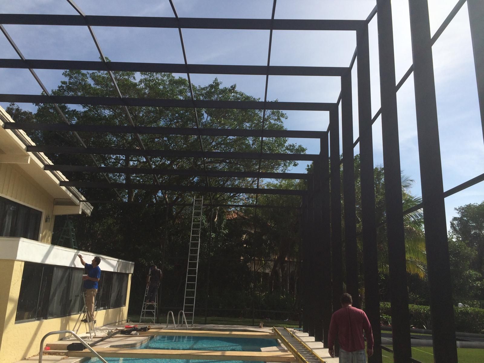 A man is standing in front of a pool with a ladder in the background