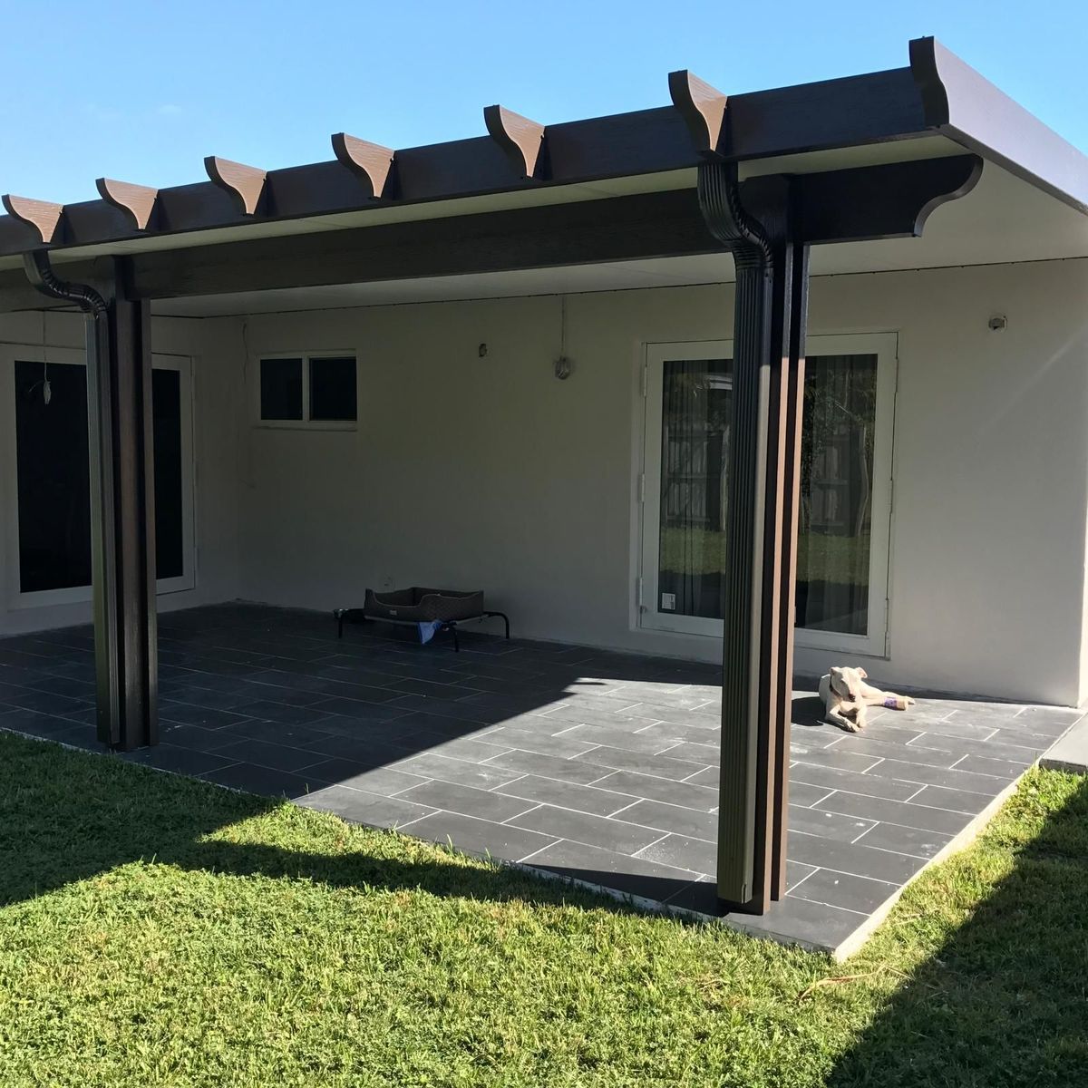 A white house with a pergola in the backyard