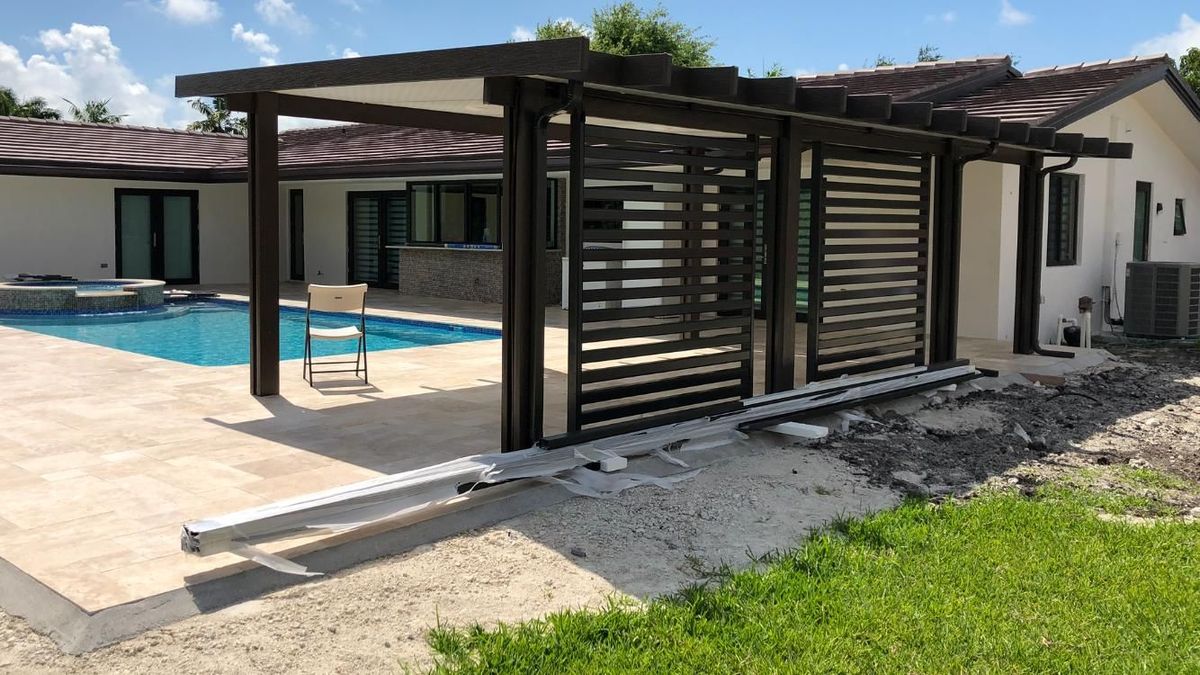 A house with a swimming pool and a pergola in front of it.