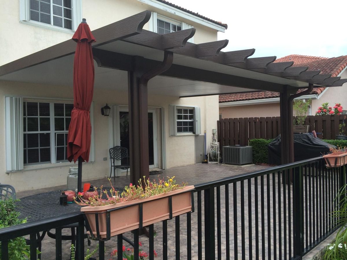 A patio with a pergola and a red umbrella