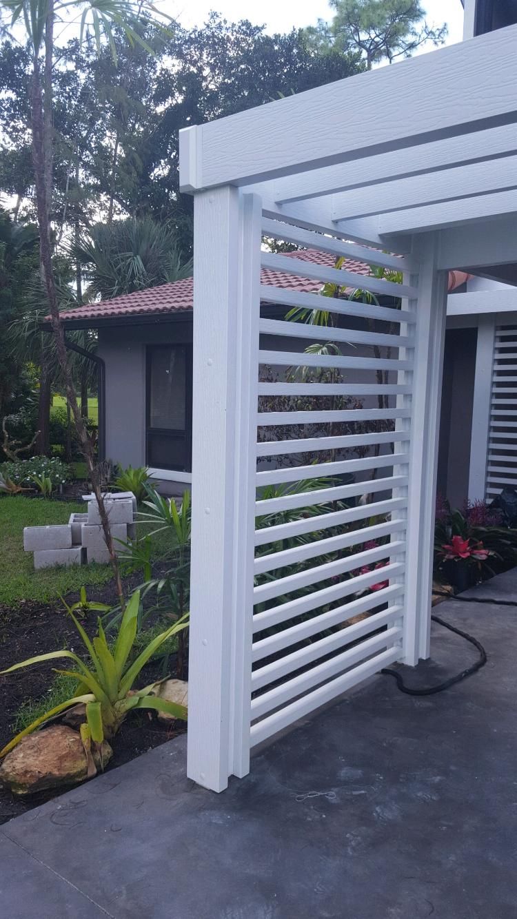 A white pergola is being built in the backyard of a house.