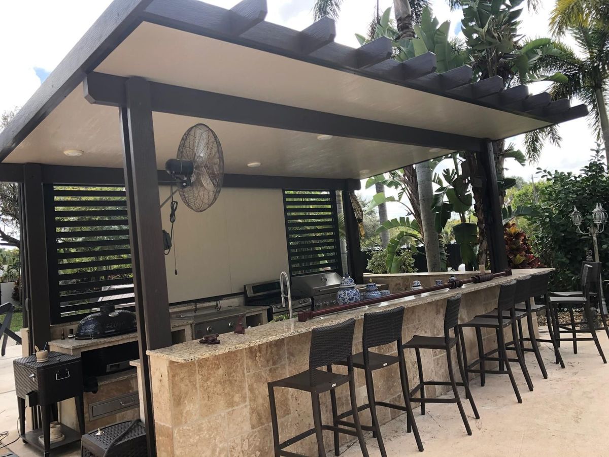 A patio with a bar and chairs under a pergola