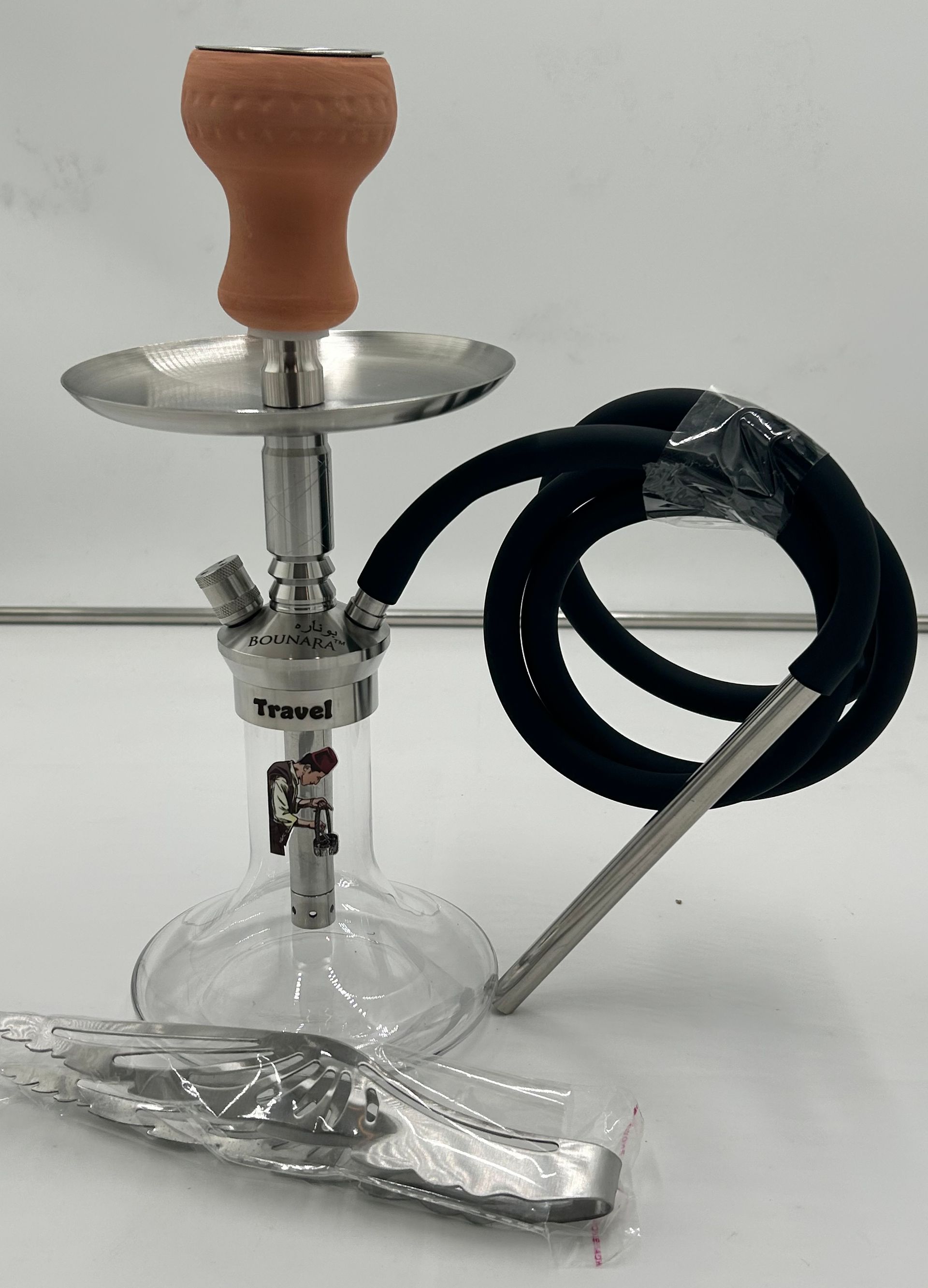 Glass hookah with a wood stem, metal tray, and black hose on a white surface