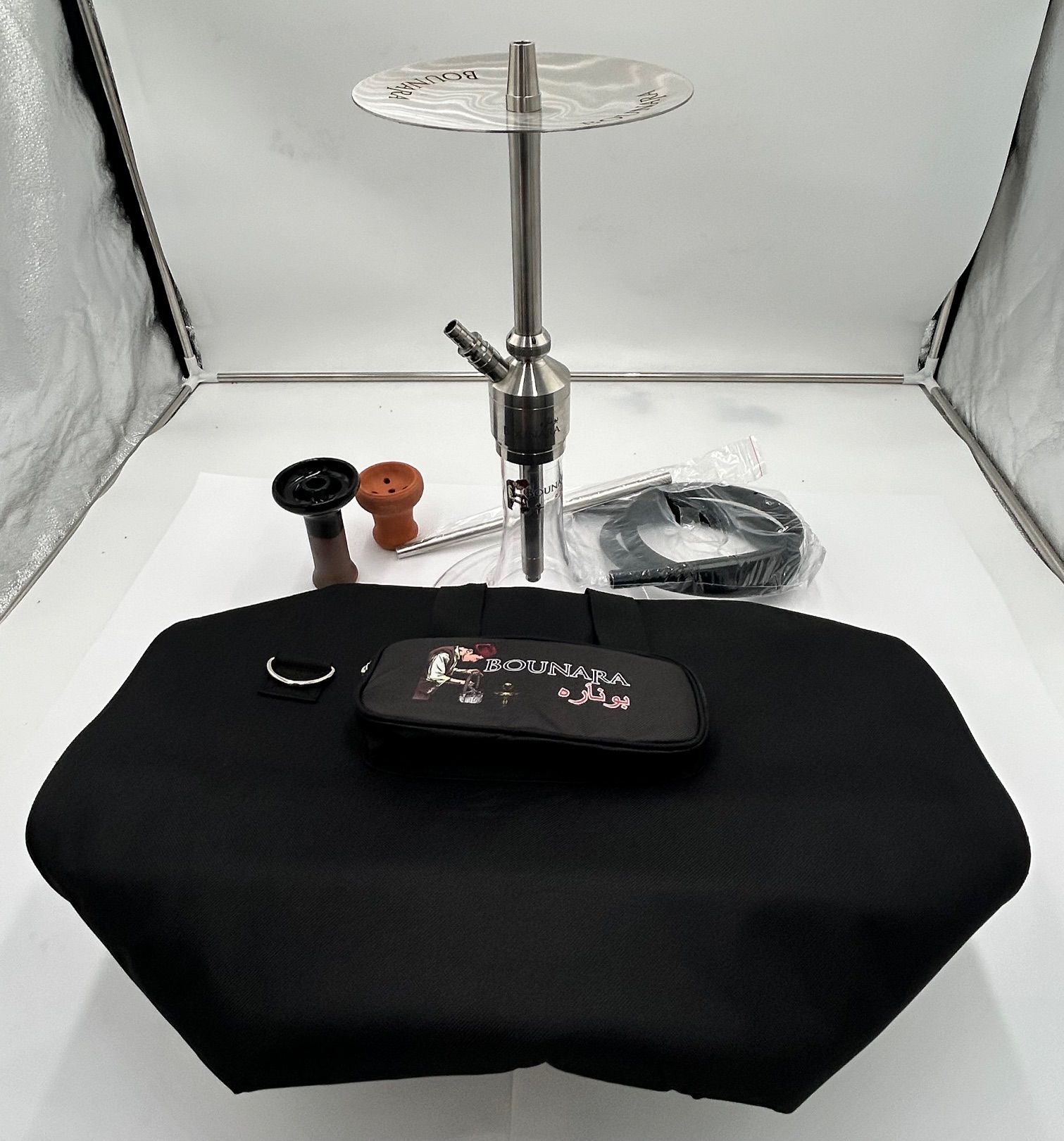 Hookah set with silver metal stem, black hose, bowl, and carrying bag on a white backdrop.