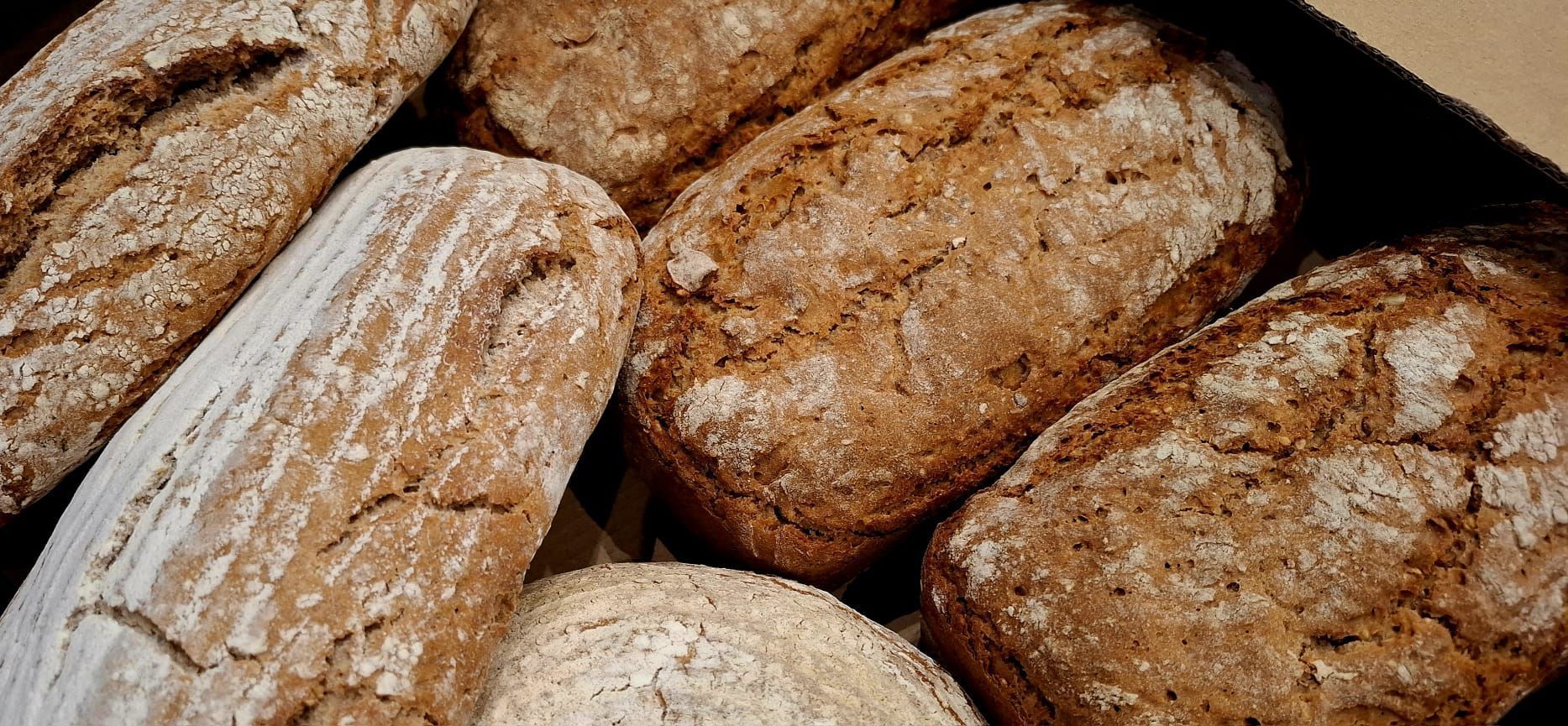 Brote in verschiedenen Formen und Größen, mit Mehl bestäubt. Braune Kruste.