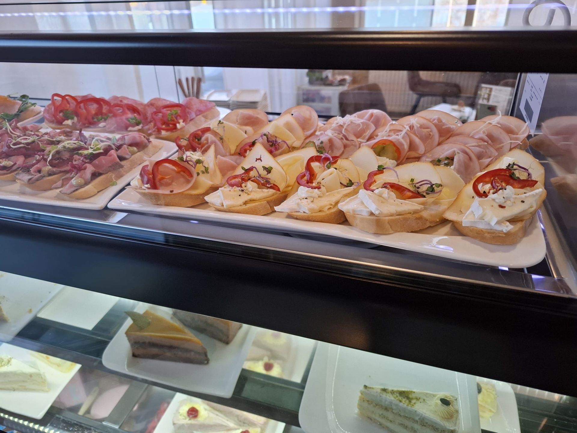 Vitrine mit verschiedenen Vorspeisen und Kuchen.