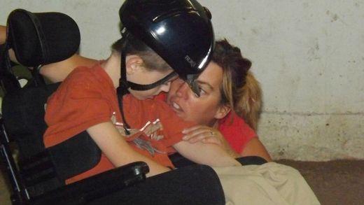 Photo: Stephanie & young rider in wheelchair with helmet
