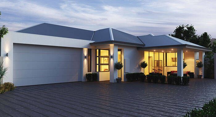 A living room with a white couch and a thermostat on the wall.