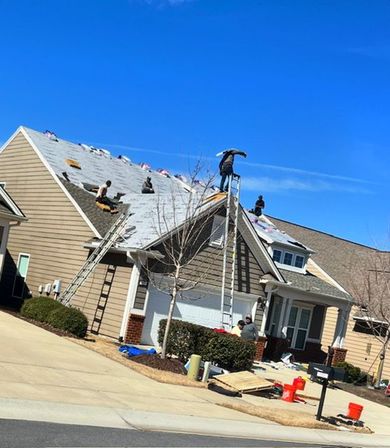 Workers repairing storm-damaged roof on beige house under a clear blue sky