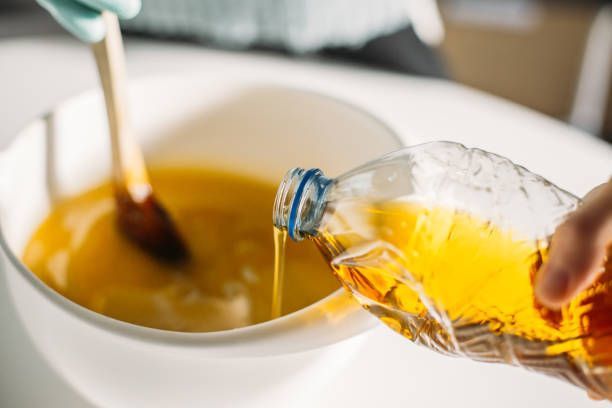 A person is pouring oil into a pan.
