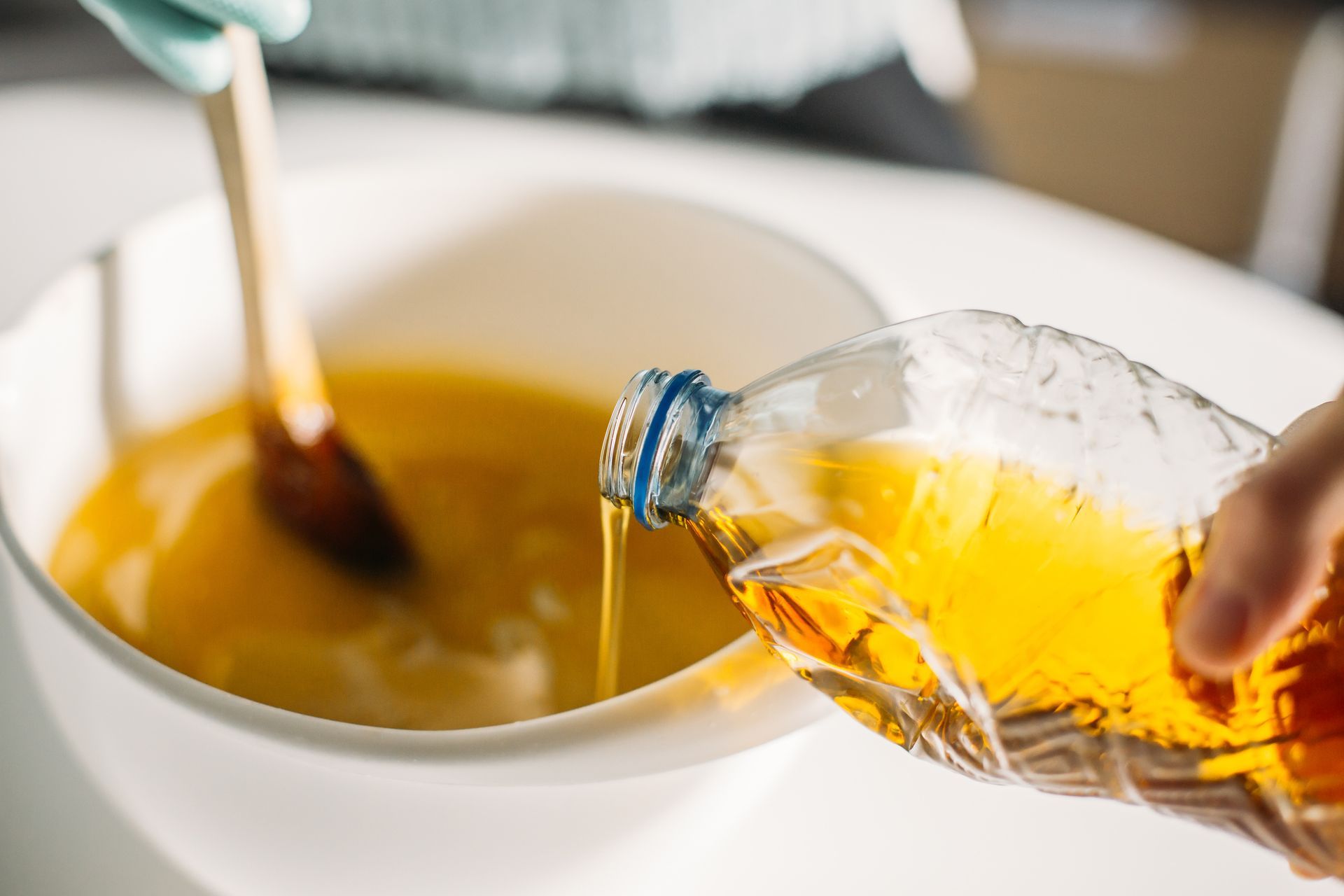 A person is pouring oil into a pan. A person is pouring oil into a pan.