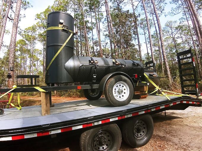 A large black barrel is sitting on top of a trailer.