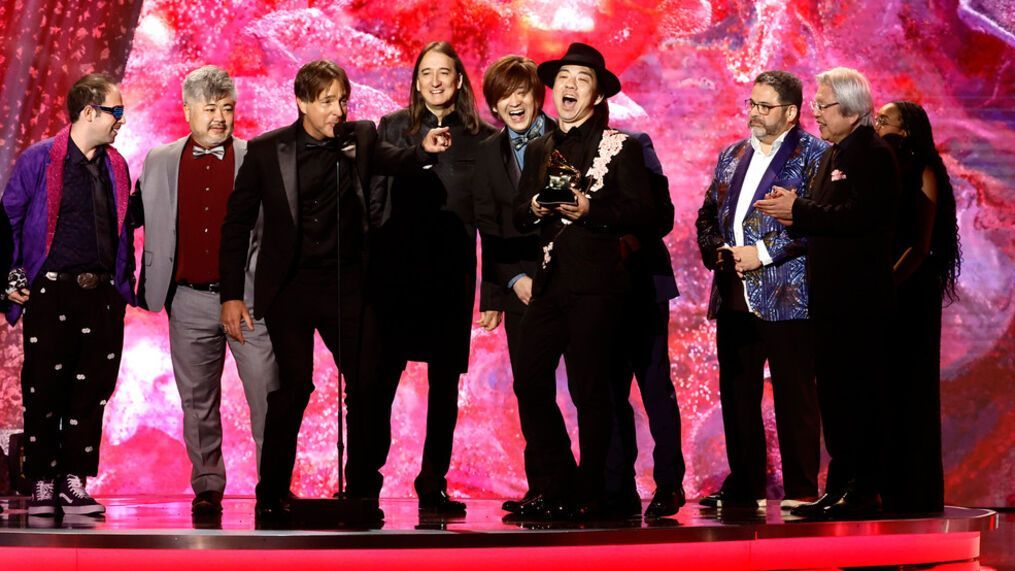 A group of men are standing on a stage holding awards.