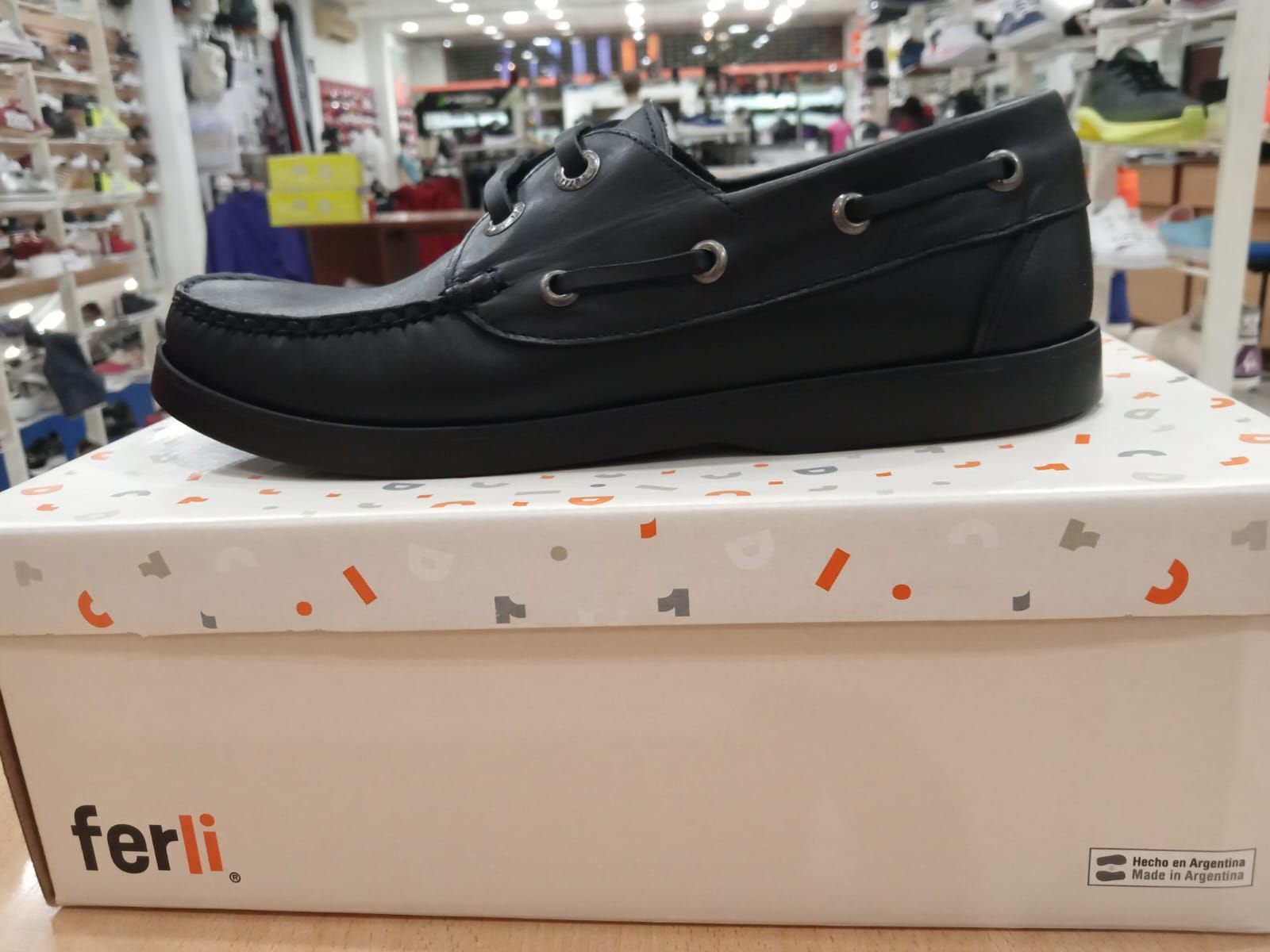 Zapato náutico negro en una caja de zapatos estampada con la etiqueta 