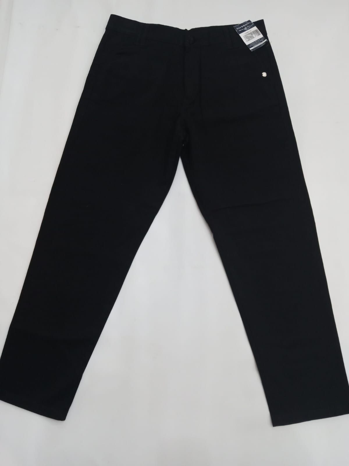 Pantalones negros extendidos sobre un fondo blanco, con una etiqueta de precio cerca de la cintura.
