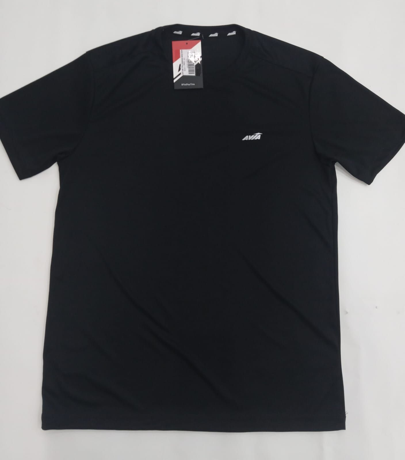 Camiseta negra de manga corta con un pequeño logo blanco en el pecho, extendida sobre un fondo claro.